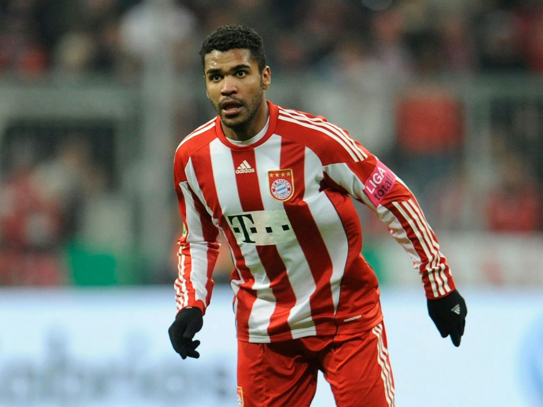 Breno steht auf dem Platz der Allianz-Arena. Er trägt das Trikot des FC Bayern sowie Adidas-Handschuhe.