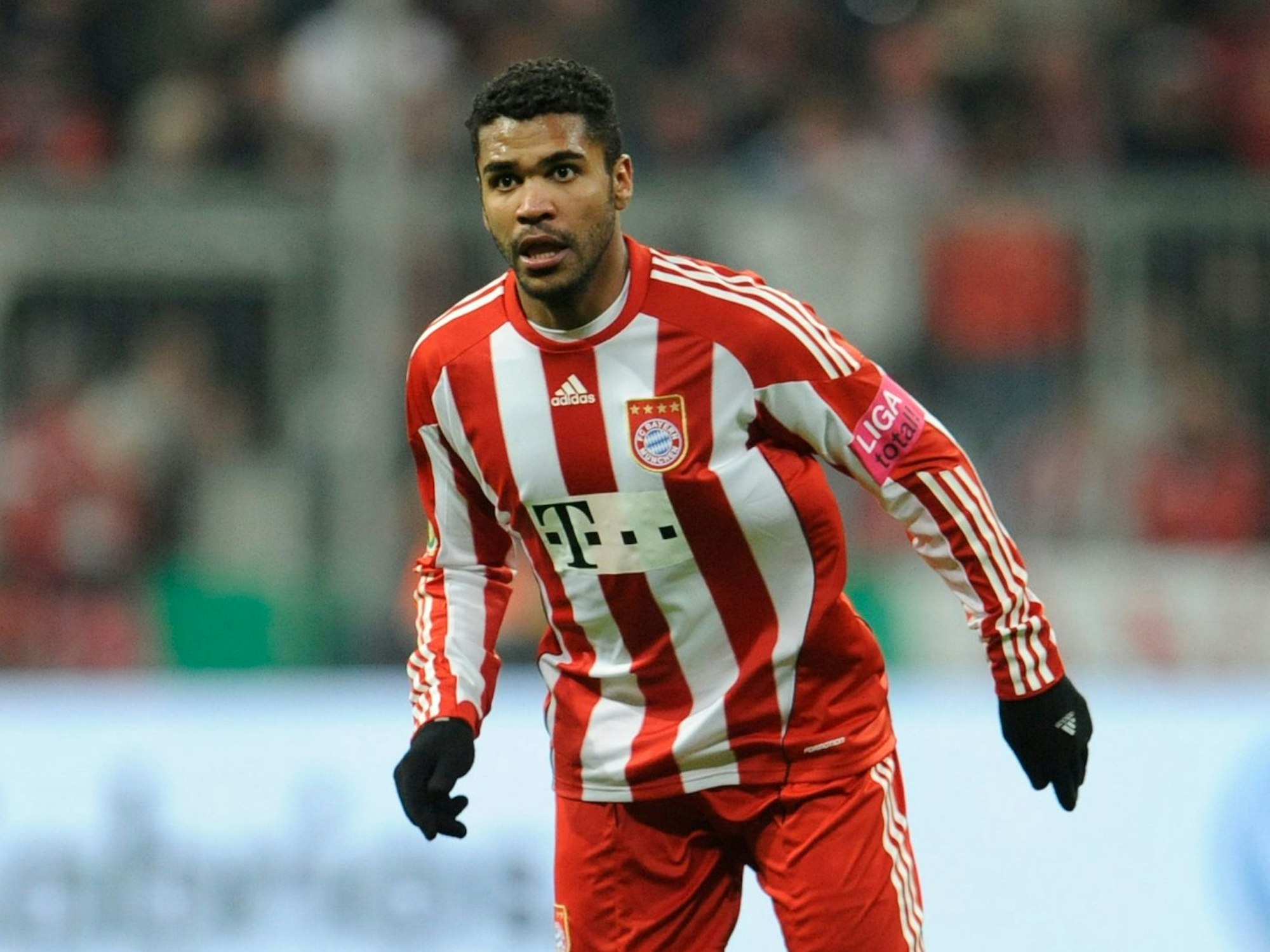 Breno steht auf dem Platz der Allianz-Arena. Er trägt das Trikot des FC Bayern sowie Adidas-Handschuhe.