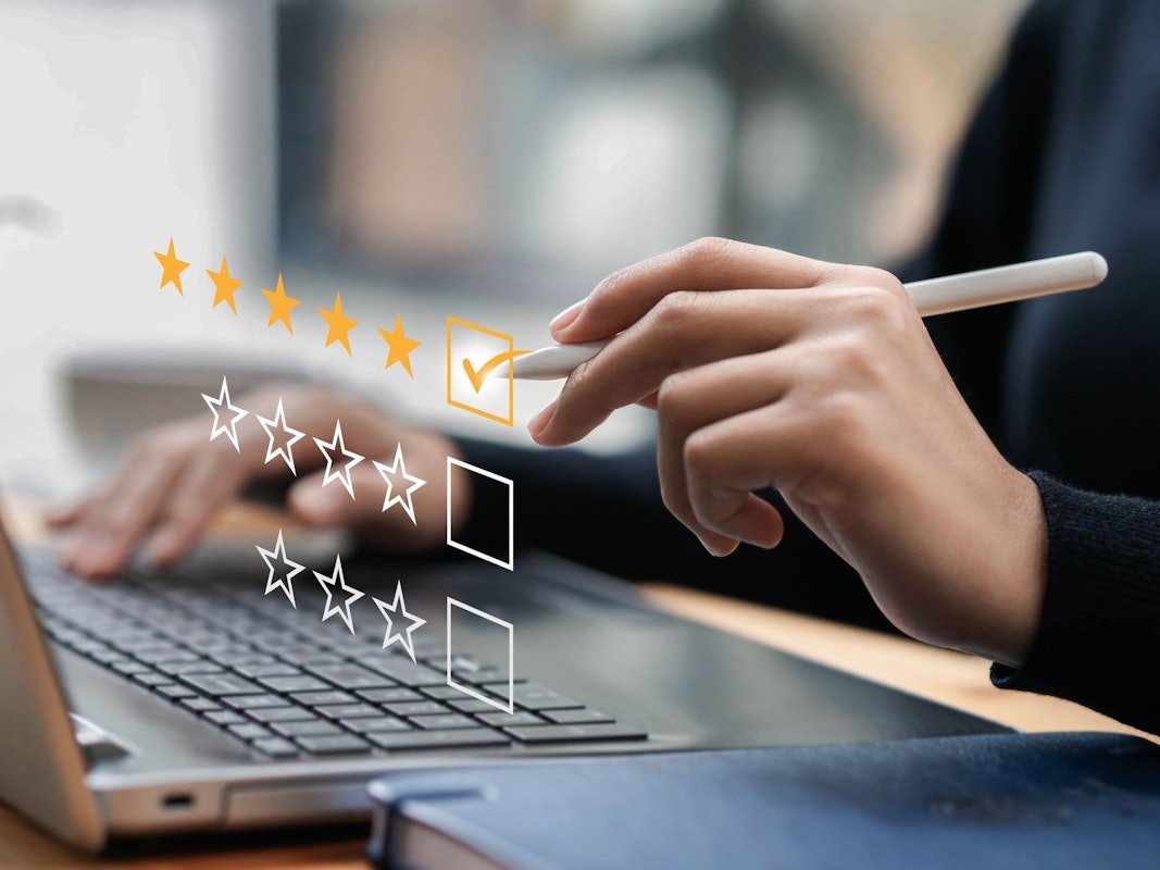 Geschäftsmann, der auf einer Computertastatur tippt, Kundenzufriedenheitsumfragekonzept. Geschäftsleute wählen die höchste Zufriedenheitsbewertung und geben 5 Sterne