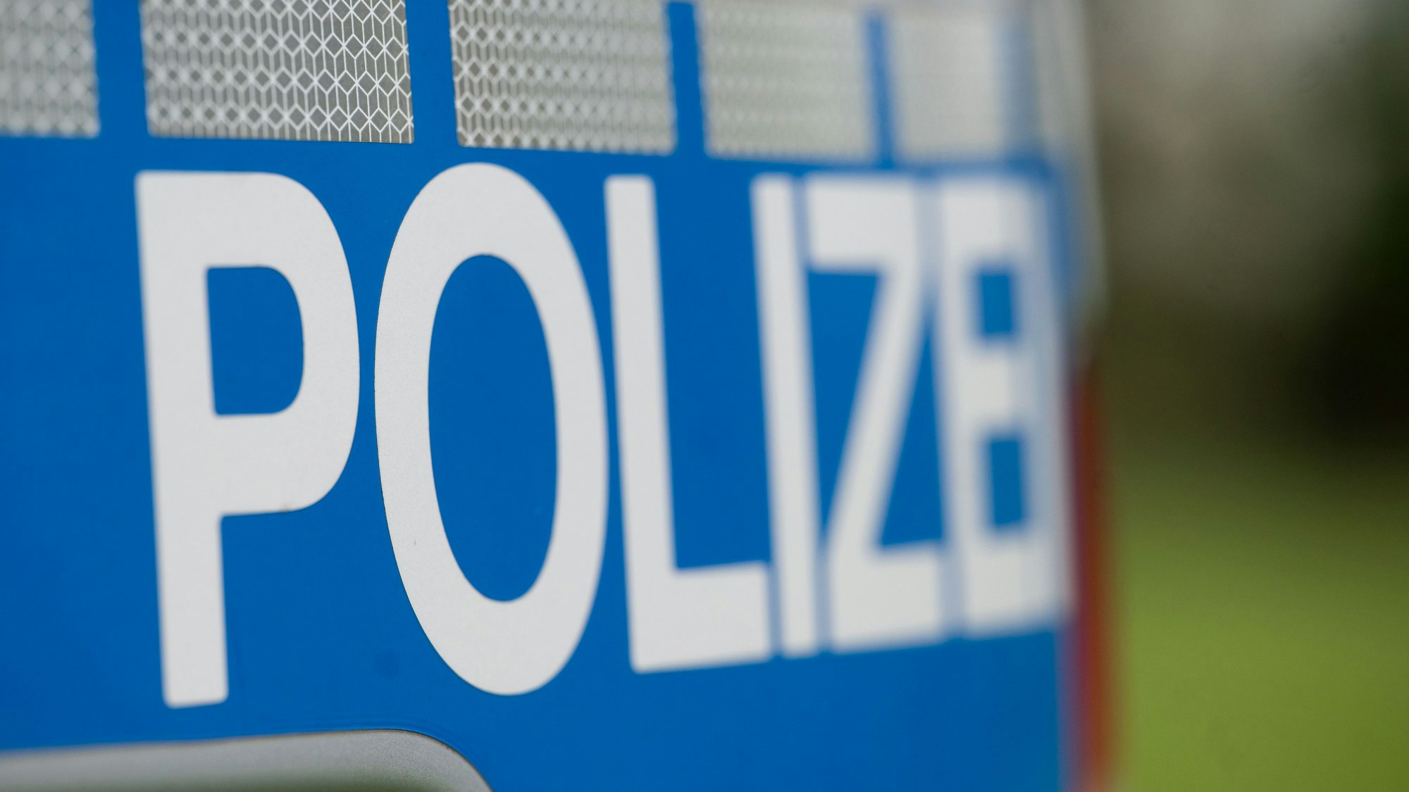 Das Wort Polizei steht auf einem Polizeiwagen.