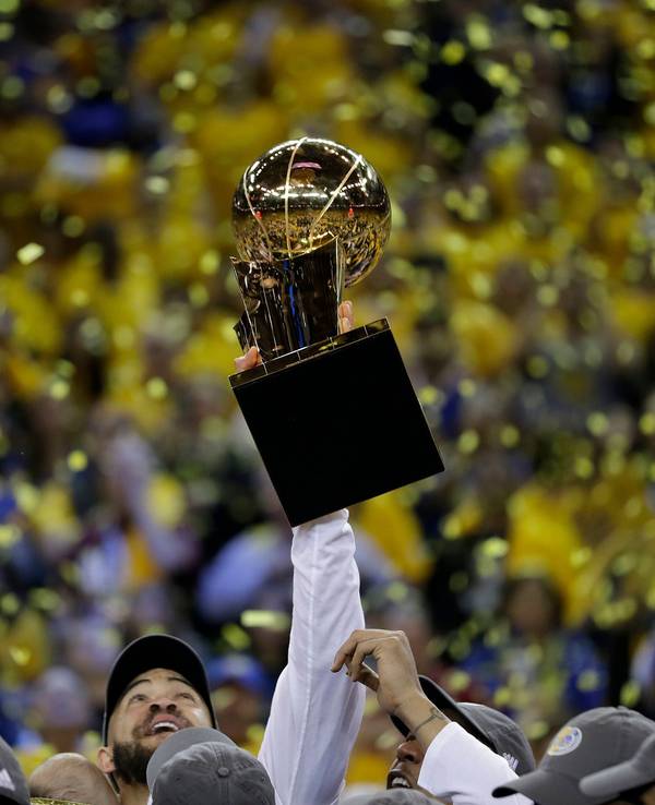 Golden States JaVale McGee jubelt und hält den «Larry O'Brien NBA Championship»-Pokal nach dem Sieg und der gewonnenen Meisterschaft hoch.