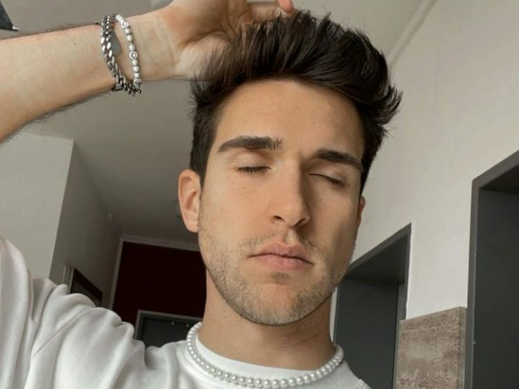 Lukas Küchen, Mr. Gay Germany 2023, fasst sich mit geschlossenen Augen an den Kopf.
