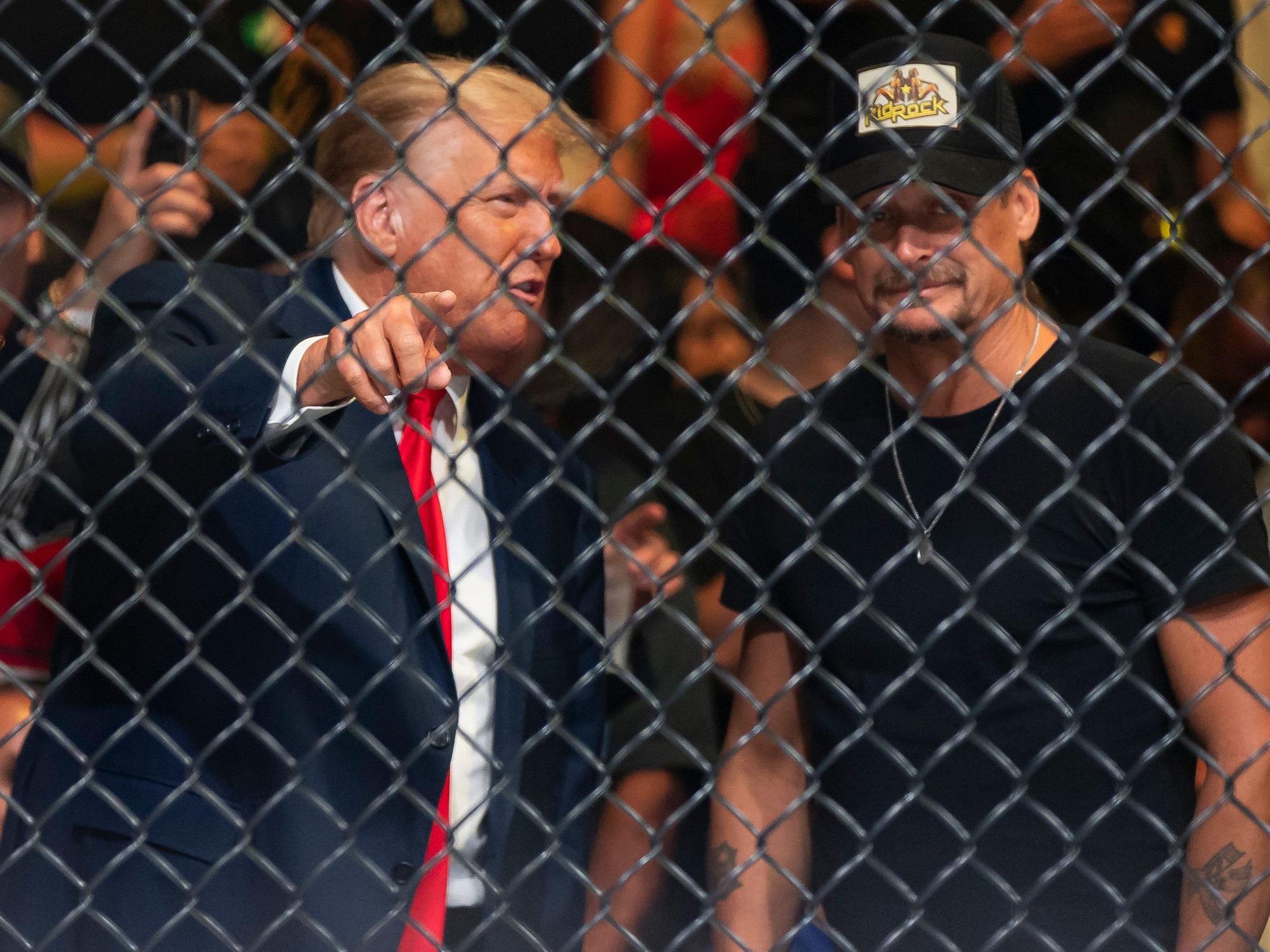Donald Trump (l), ehemaliger Präsident der USA, und Kid Rock (r), Musiker aus den USA, unterhalten sich während des Kampfsportevents in Miami.