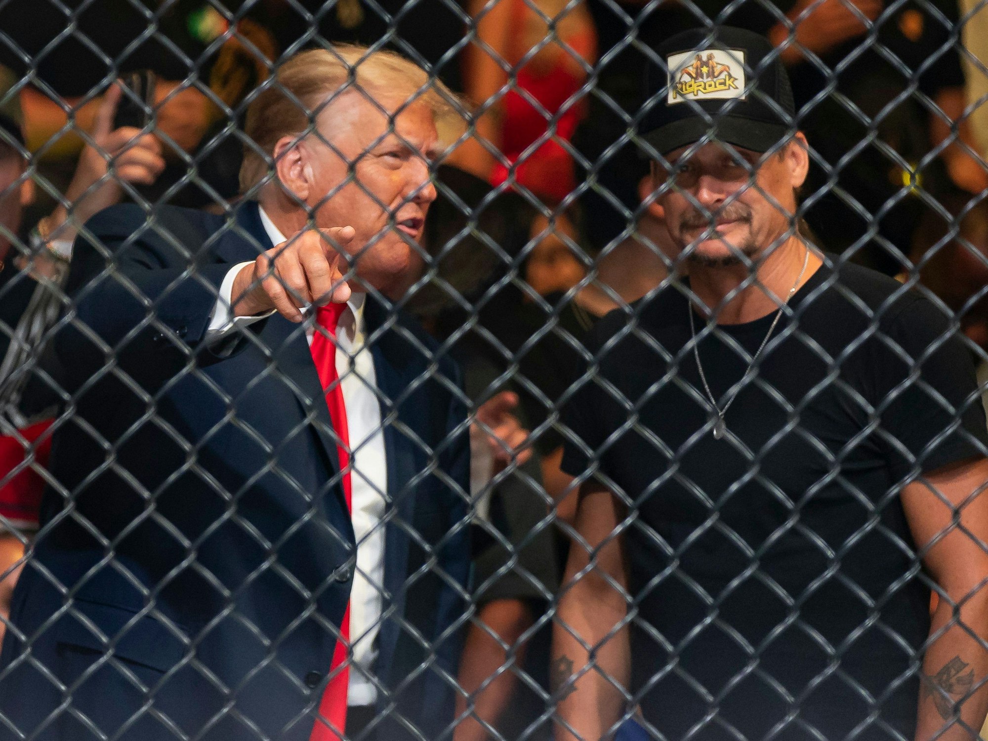 Donald Trump (l), ehemaliger Präsident der USA, und Kid Rock (r), Musiker aus den USA, unterhalten sich während des Kampfsportevents in Miami.