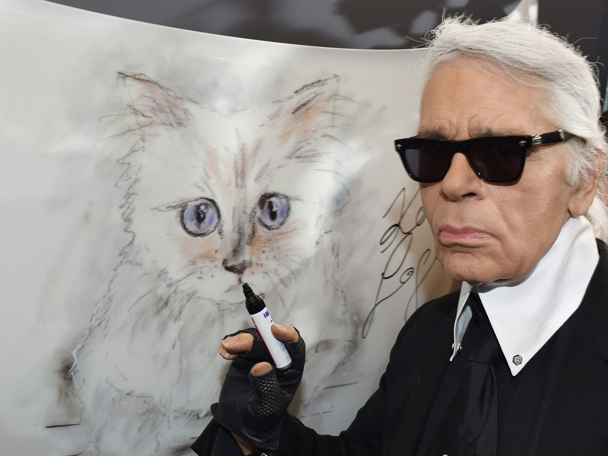 Der Mode-Designer Karl Lagerfeld und eine Zeichnung seiner Katze „Choupette“ für seinen Fotokalender in 2015.