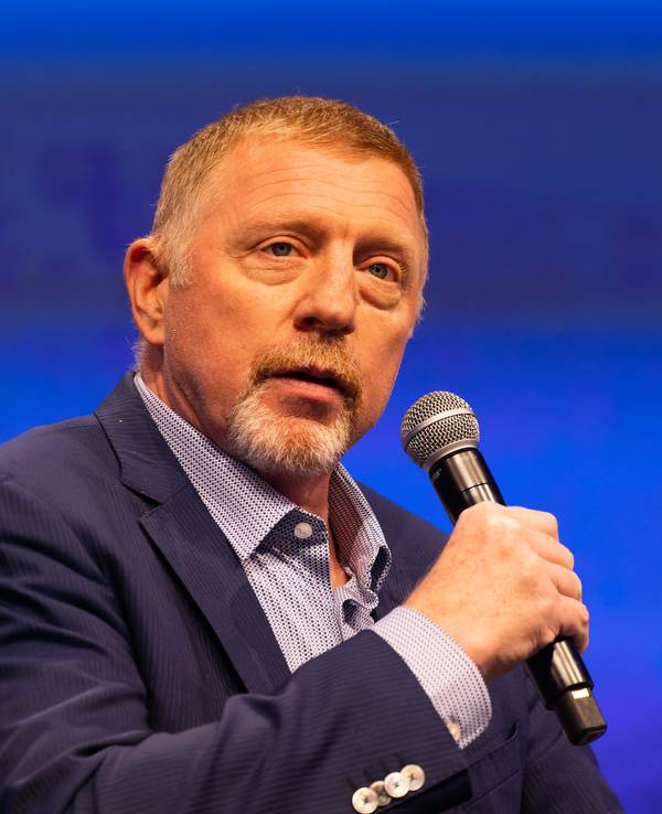 Boris Becker hat ein Mikrofon in der Hand.