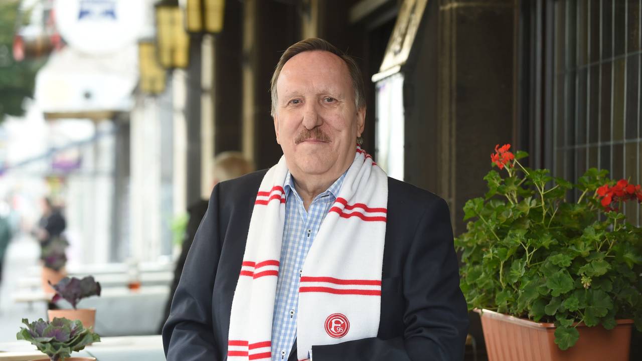 Dieter Bierbaum steht am Tisch und lächelt in die Kamera.