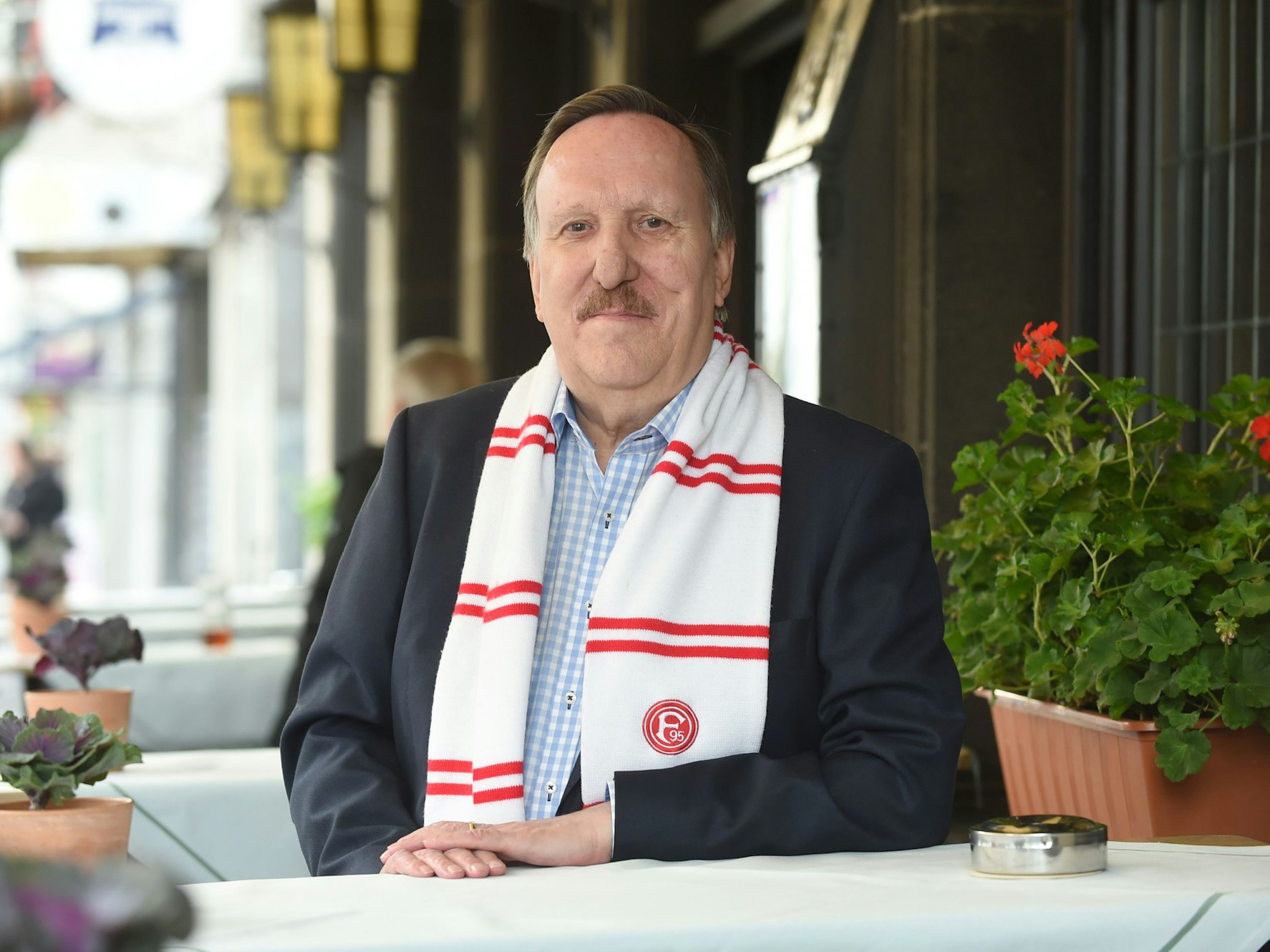 Dieter Bierbaum steht am Tisch und lächelt in die Kamera.