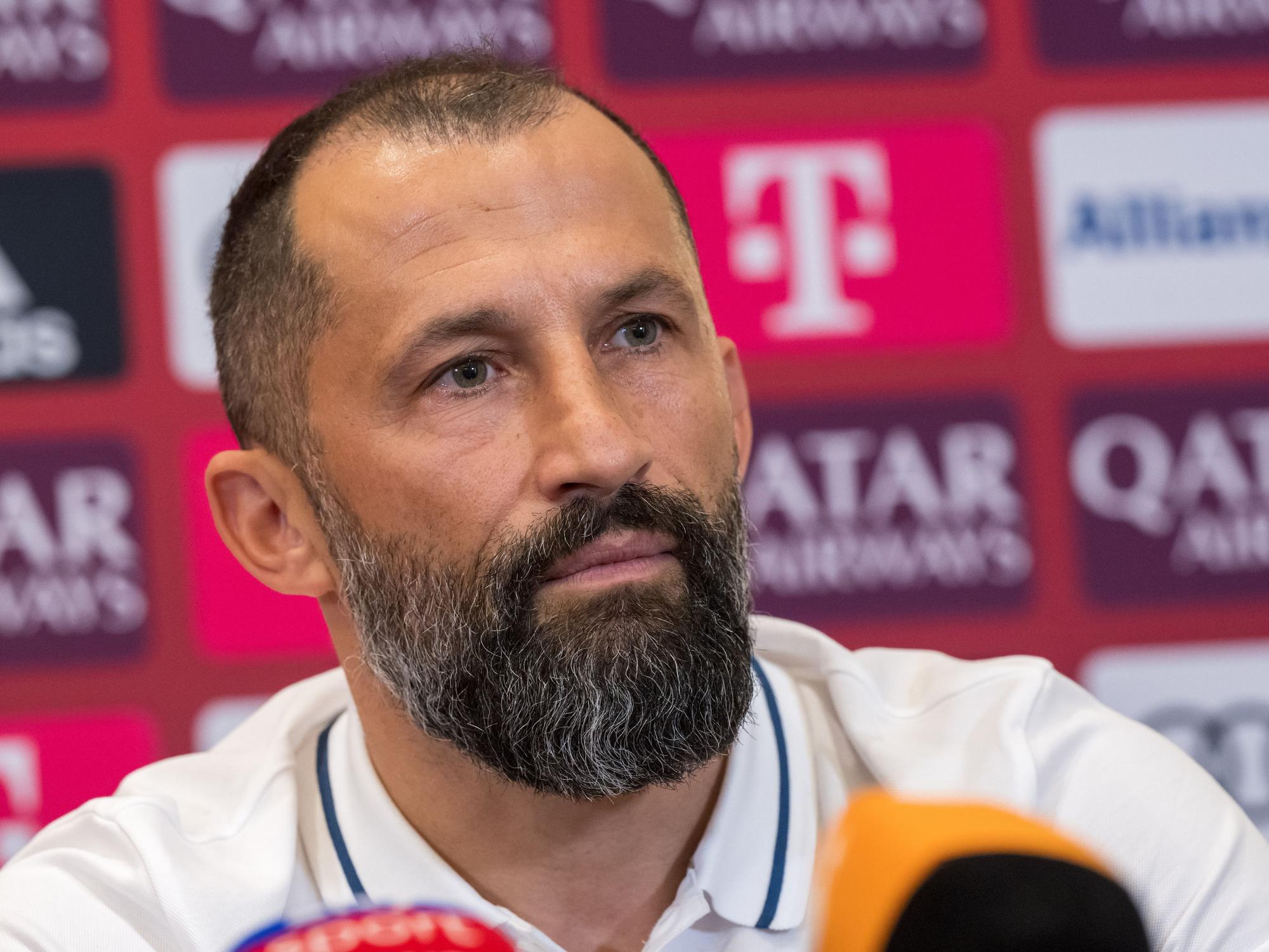 Sportvorstand Hasan Salihamidzic nimmt an einer Pressekonferenz des FC Bayern München teil. Er sitzt auf dem Podium.