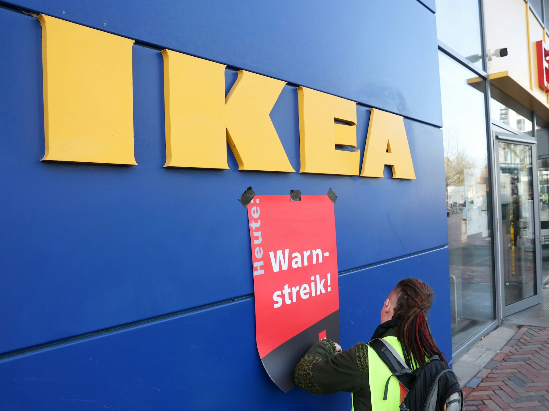 Während eines Warnstreiks wird ein Plakat mit der Aufschrift „Warnstreik“ an einer Ikea-Filiale in Hamburg-Altona angebracht.