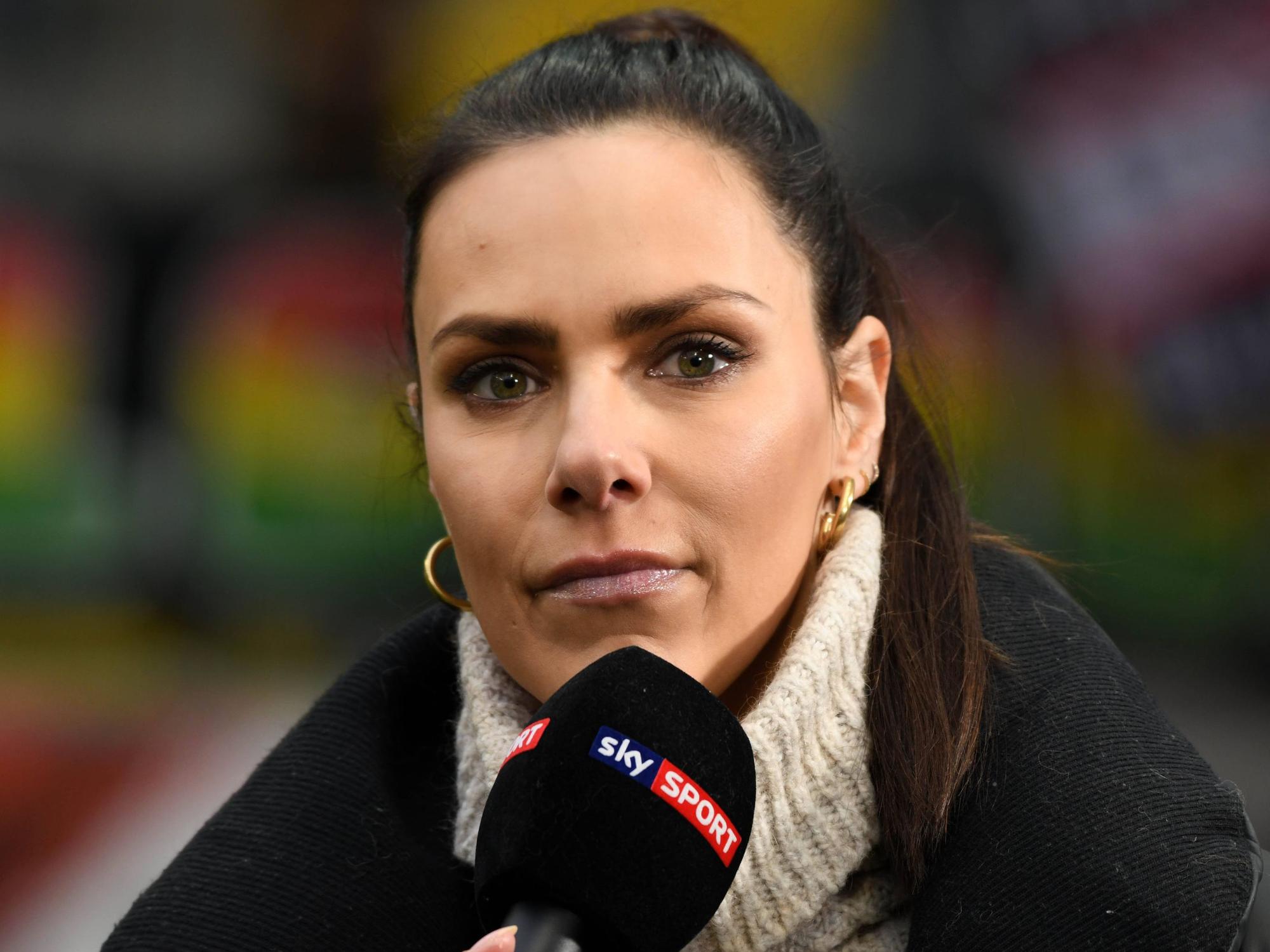 Esther Sedlaczek steht mit einem Sky-Mikro im Stadion.