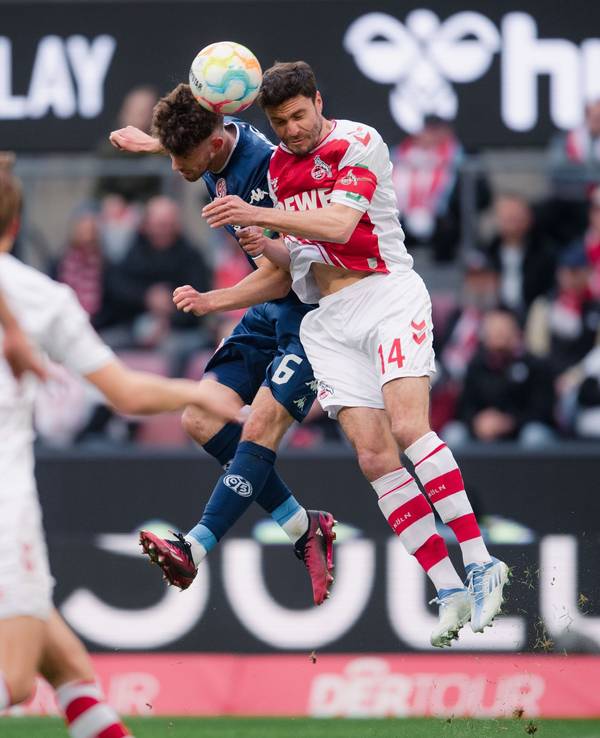 FC-Kapitän Jonas Hector und Mainz-Profi Anton Stach steigen zum Kopfballduell hoch.