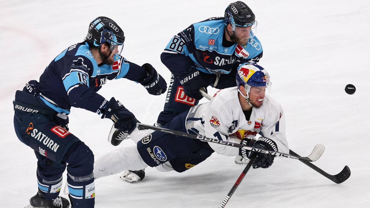 Daniel Pietta und Tye McGinn vom ERC Ingolstadt kämpfen mit Frederik Tiffels vom EHC München um den Puck.