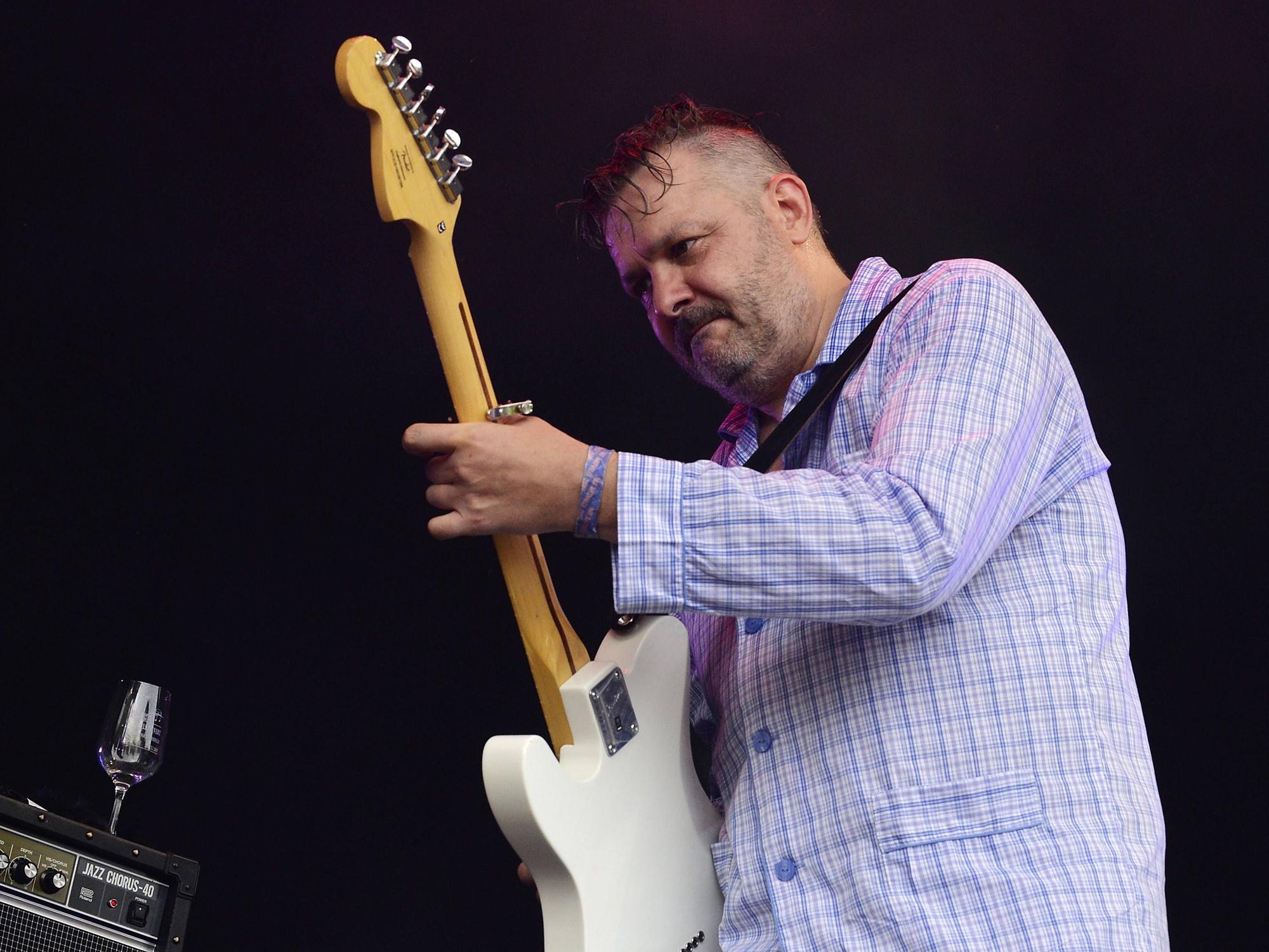 Martin Bechler steht mit Gitarre auf der Bühne.