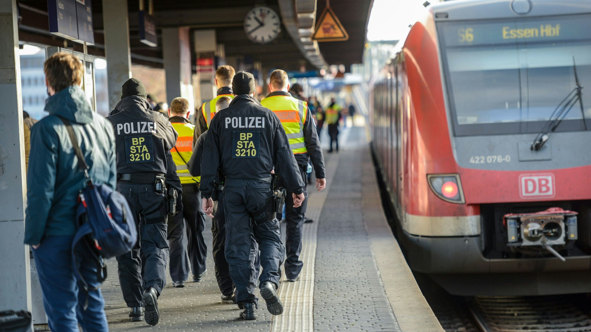 Polizei in Uniform geht durch den Bahnhof Köln Messe/Deutz und führt Kontrollen durch.