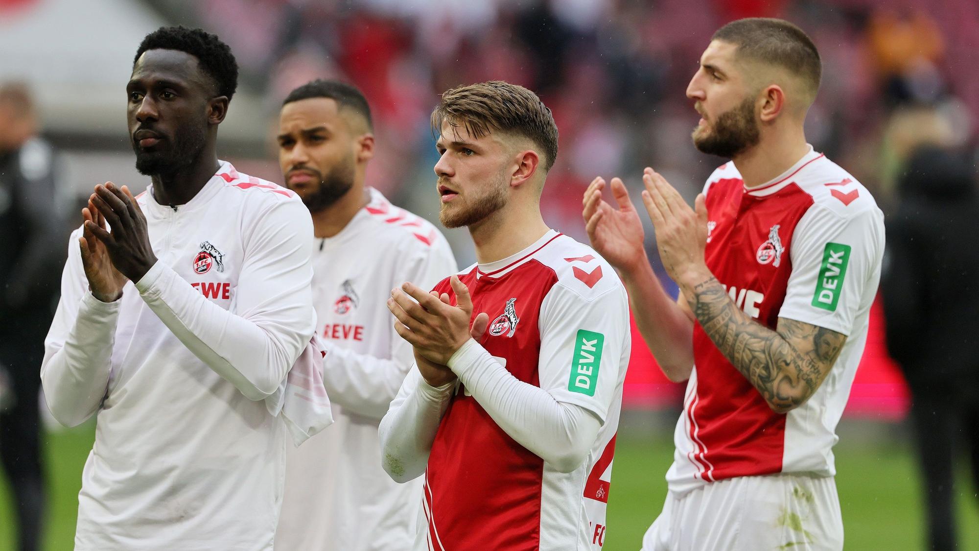 Kingsley Schindler, Linton Maina, Jan Thielmann und Jeff Chabot klatschen für die Fans des 1. FC Köln.