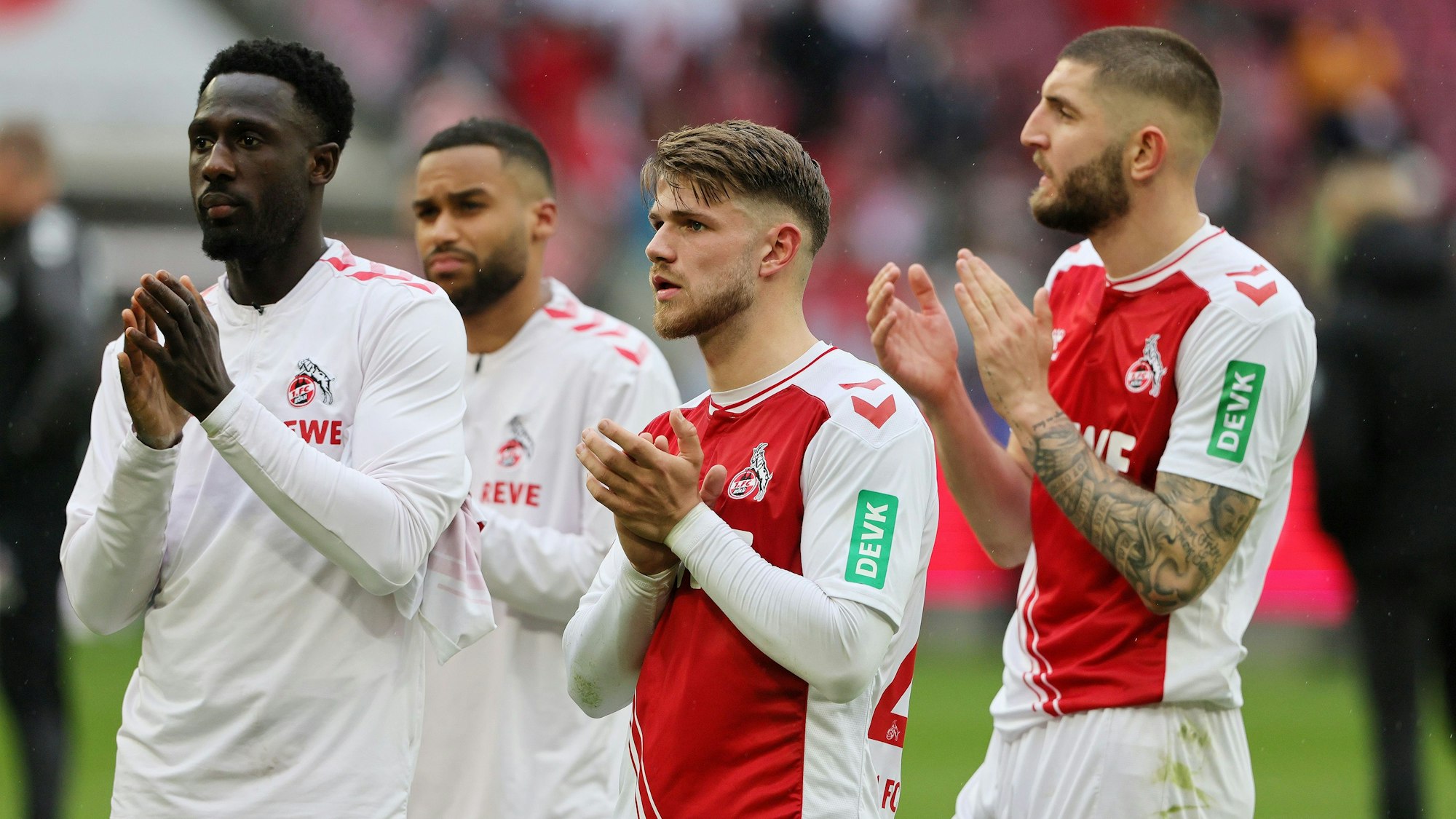 Kingsley Schindler, Linton Maina, Jan Thielmann und Jeff Chabot klatschen für die Fans des 1. FC Köln.