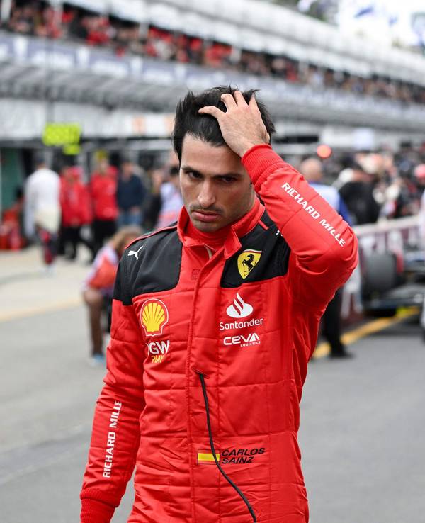 Ferrari-Pilot Carlos Sainz Jr streicht sich durchs Haar.