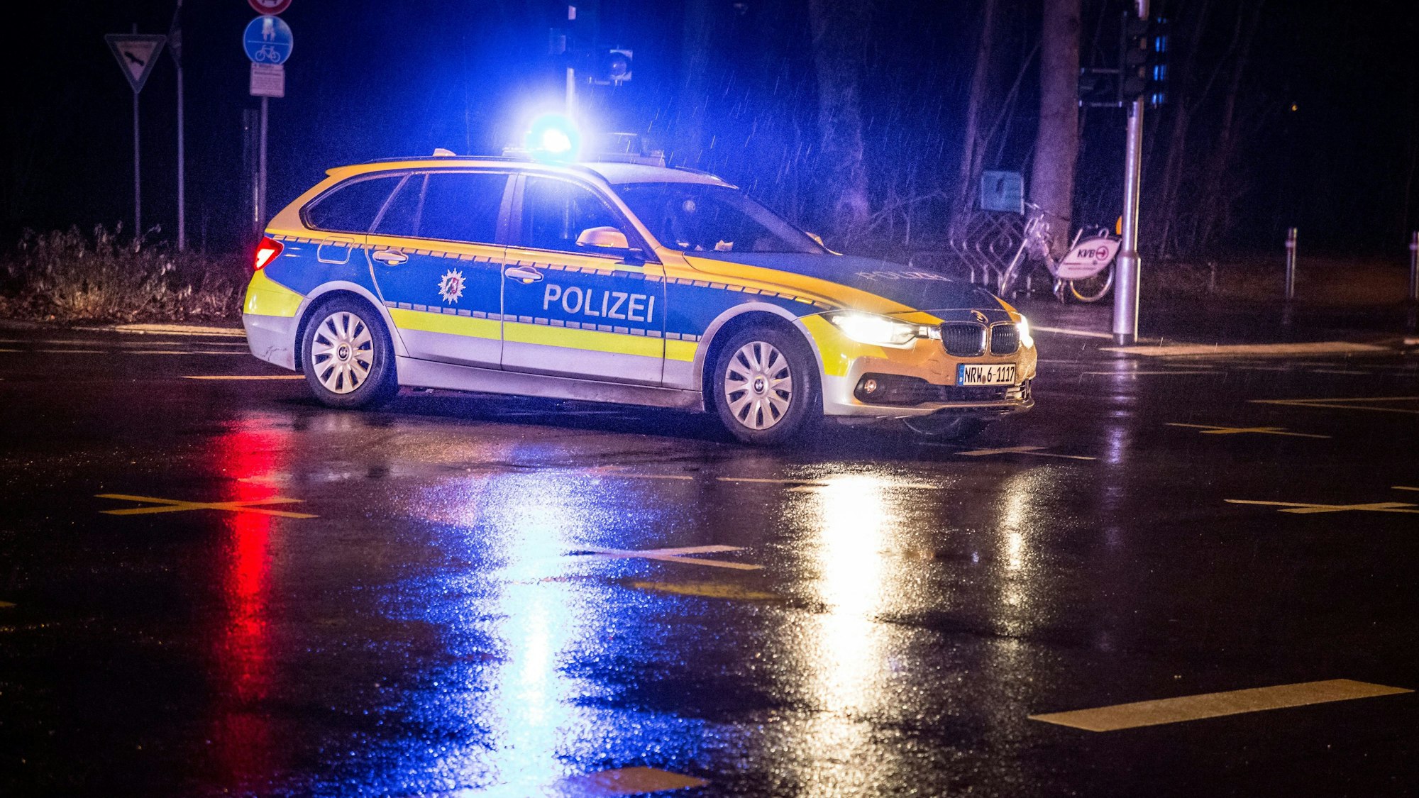 Ein Rettungswagen und ein Polizeiwagen an einer Unfallstelle in der Nacht.