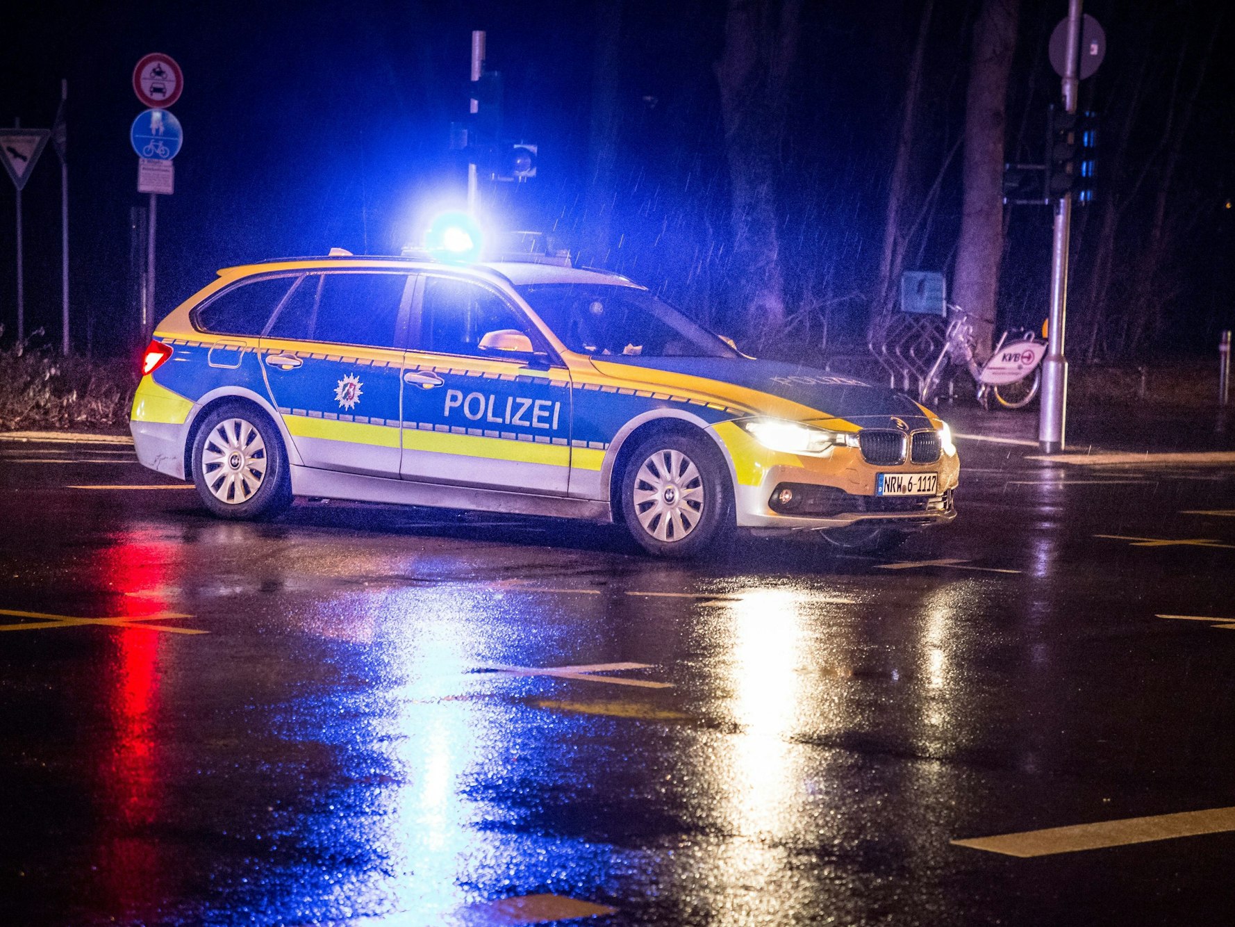 Streifenwagen der Polizei und Rettungswagen stehen nachts an einer Unfallstelle.