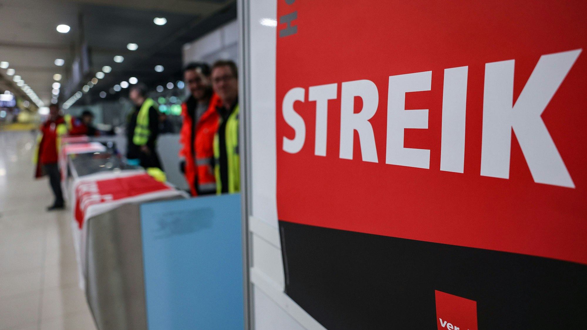 Ein Streikposten steht am Flughafen Köln/Bonn im Terminal.