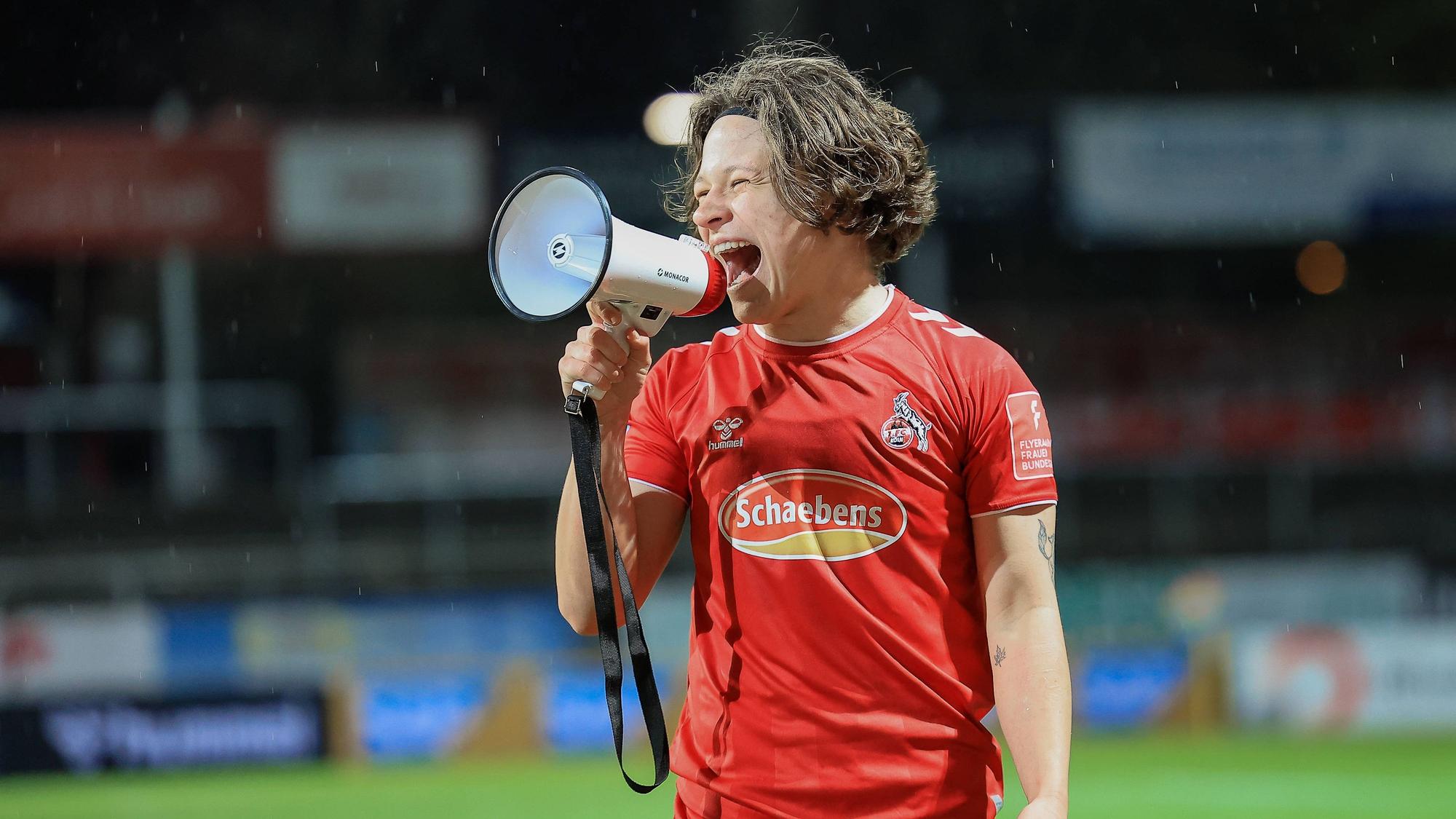 Ally Gudorf feiert mit Megafon den Sieg des 1. FC Köln gegen Duisburg.