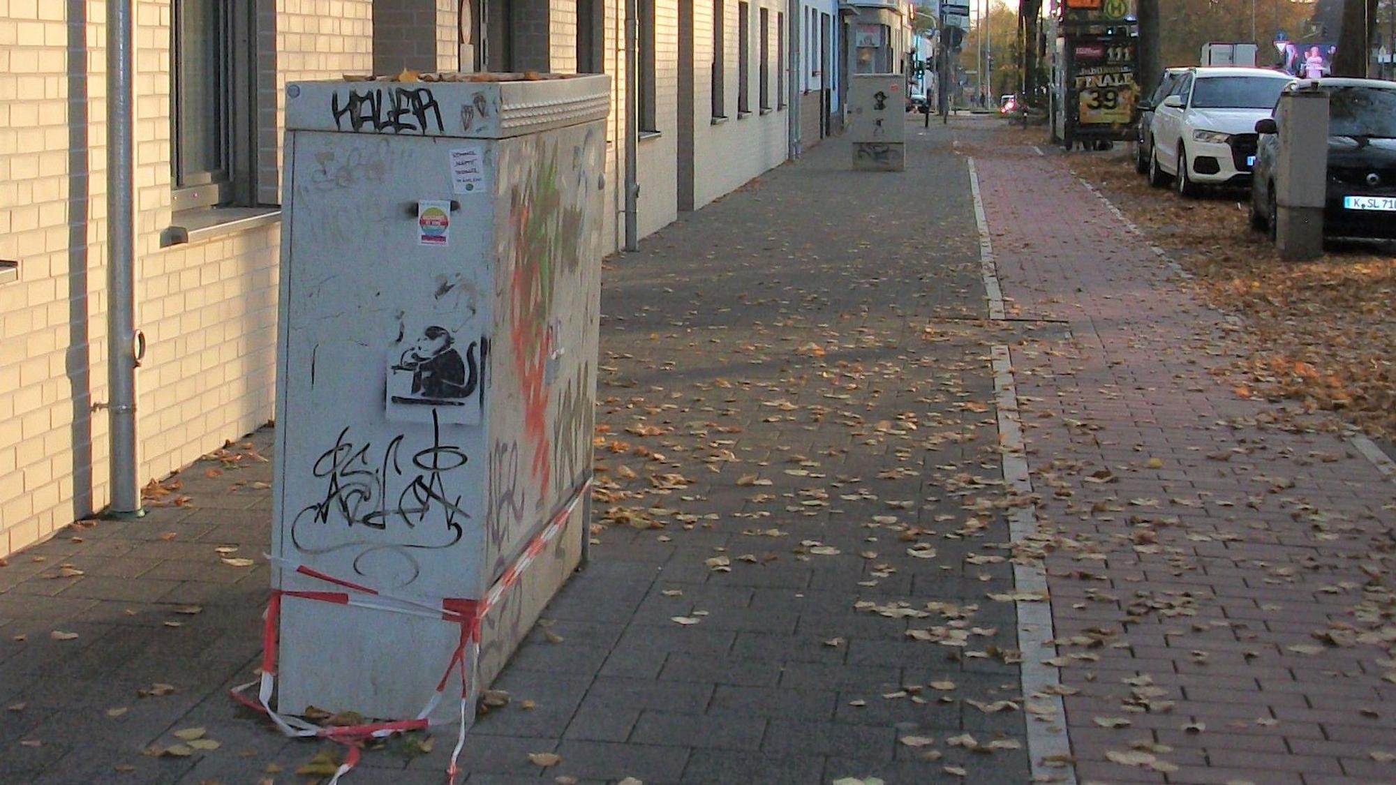 Zwei Schaltkästen stehen mitten auf einem Gehweg.