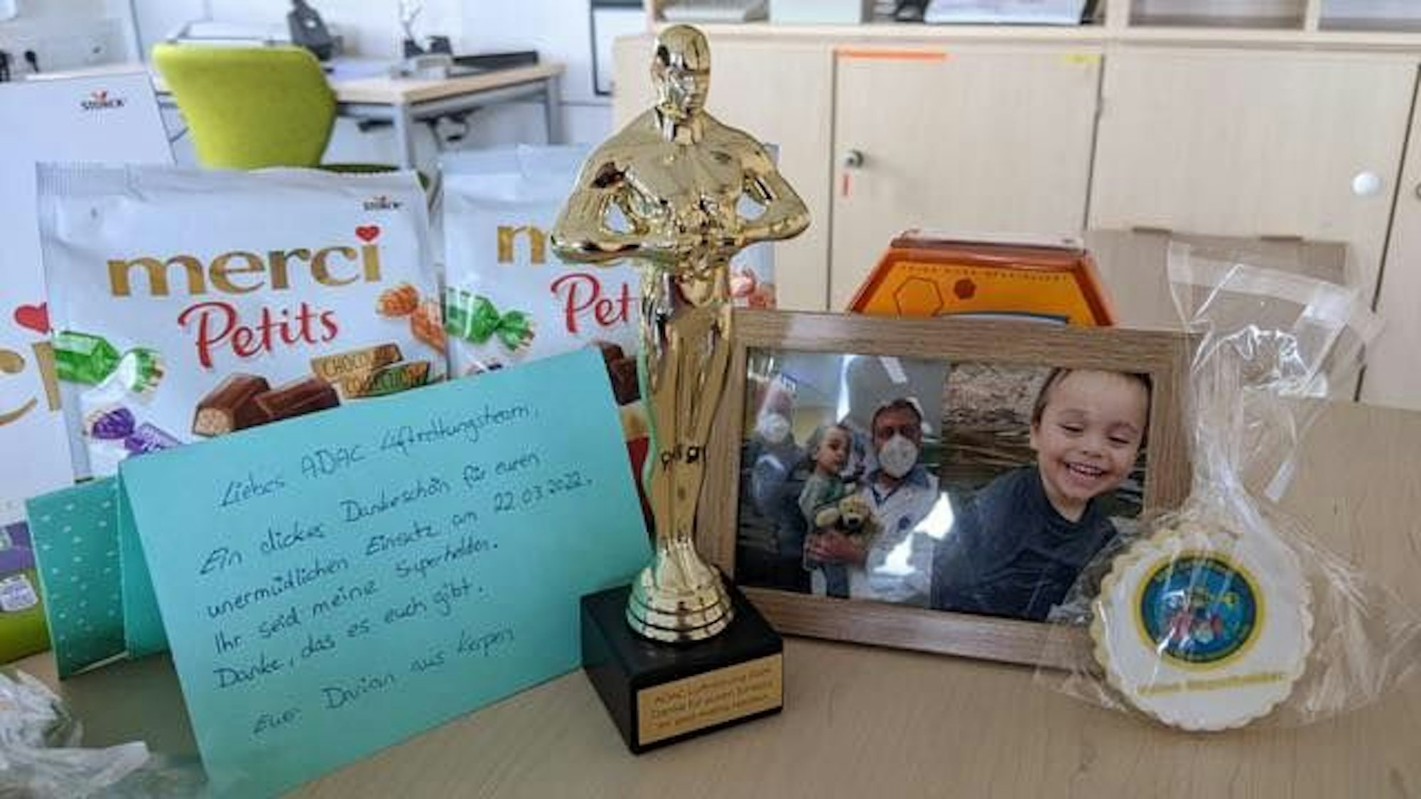 Die Geschenke und Danksagungen von Darian und seinen Eltern an die Feuerwehr Köln liegen auf einem Tisch verteilt.