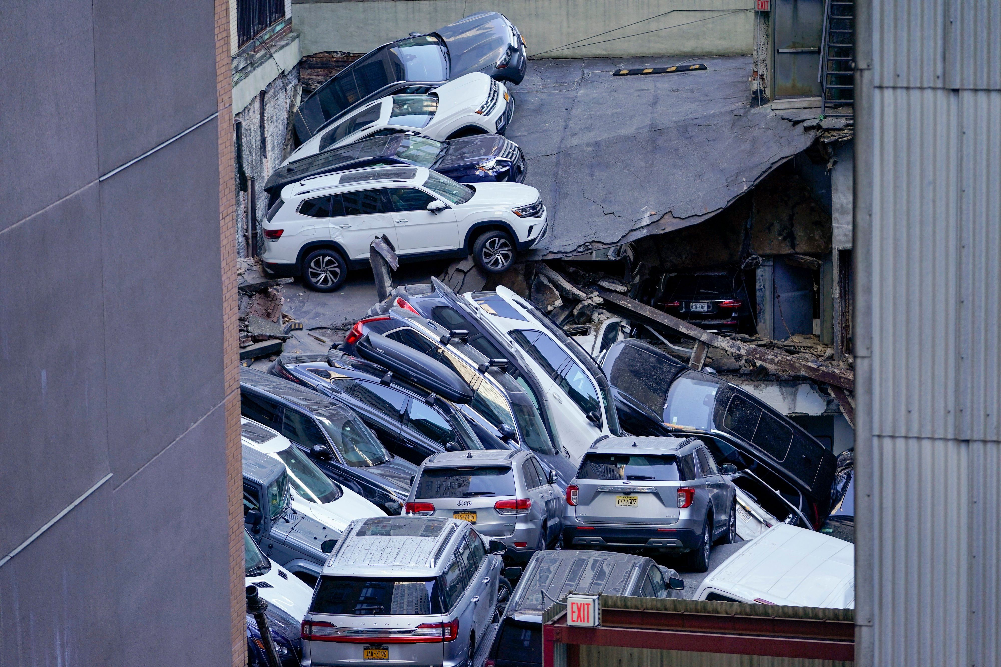 Hier zu sehen, das eingestürzte Parkhaus in New York. Auf dem Dach stapeln sich mehrere zusammengedrückte Autos.