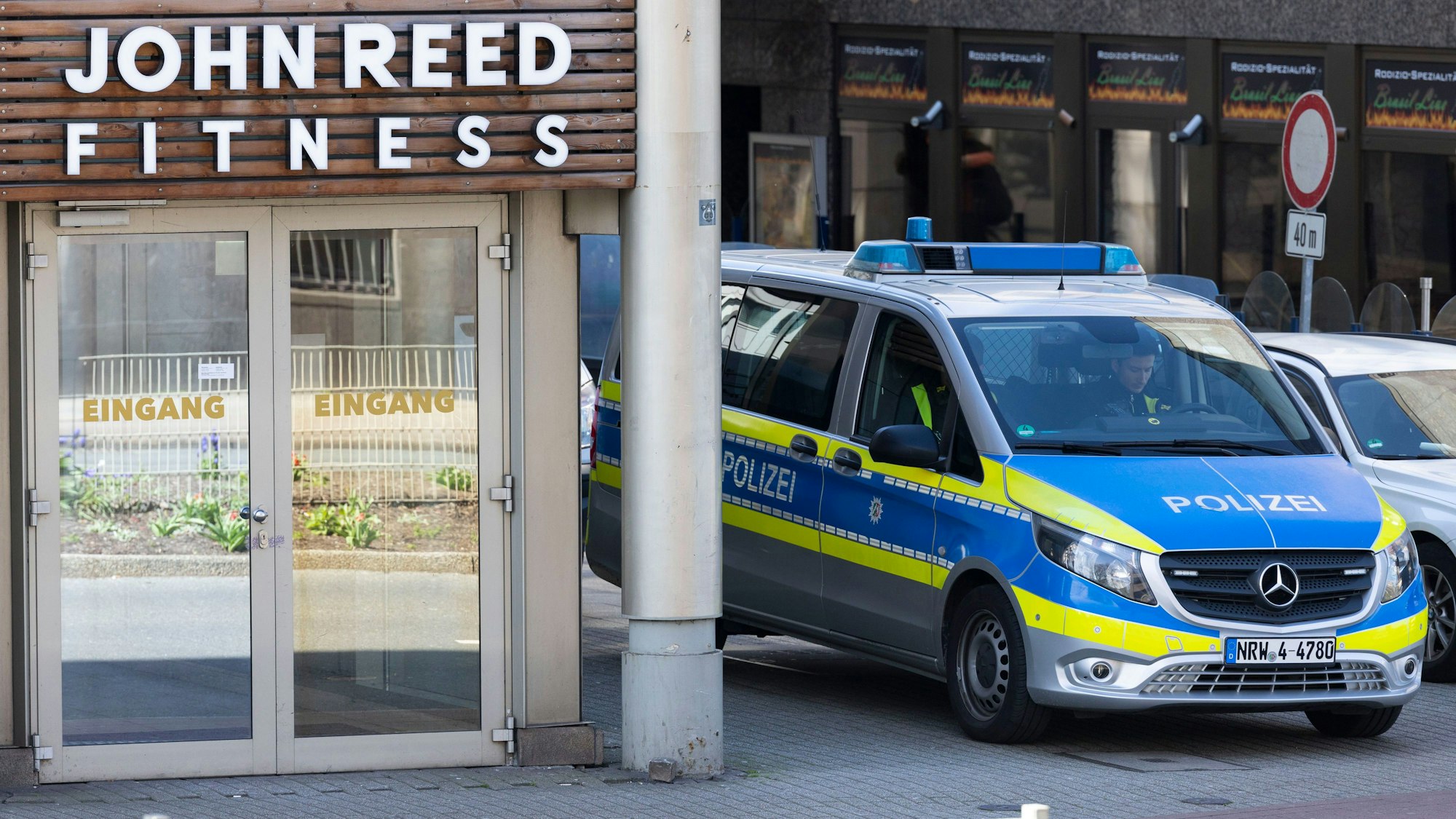 Ein Streifenwagen steht vor dem Eingang. Bei einer Attacke in einem Fitnessstudio in der Duisburger Innenstadt sind mehrere Personen schwer verletzt worden.