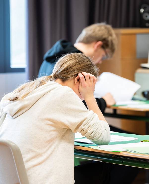 Schülerinnen und Schüler sitzen während der schriftlichen Abiturprüfung in Biologie in einem Klassenzimmer im Leibniz-Gymnasium.