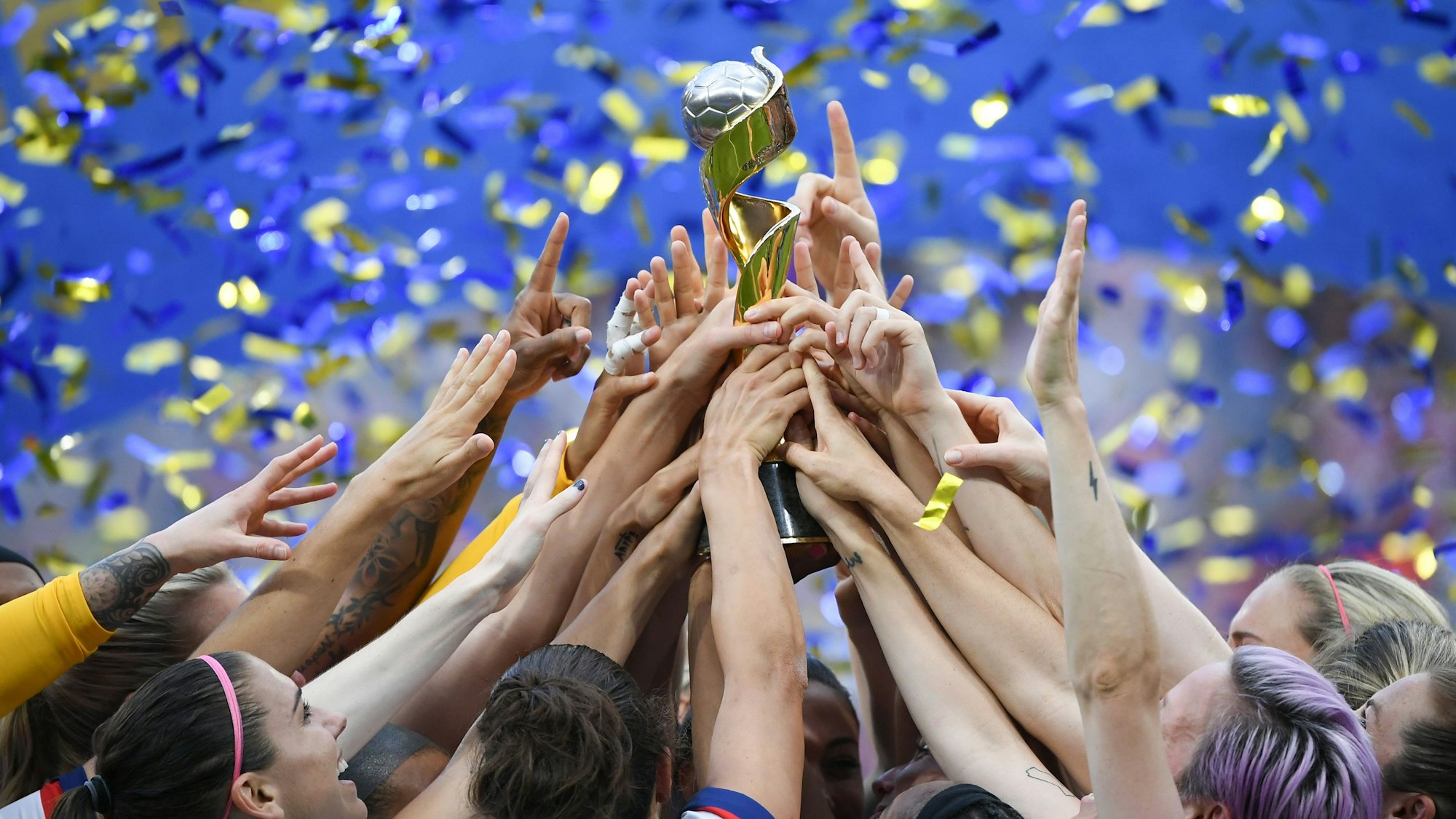 Die US-Spielerinnen feiern ihren Sieg und halten gemeinsam den WM-Pokal nach oben.