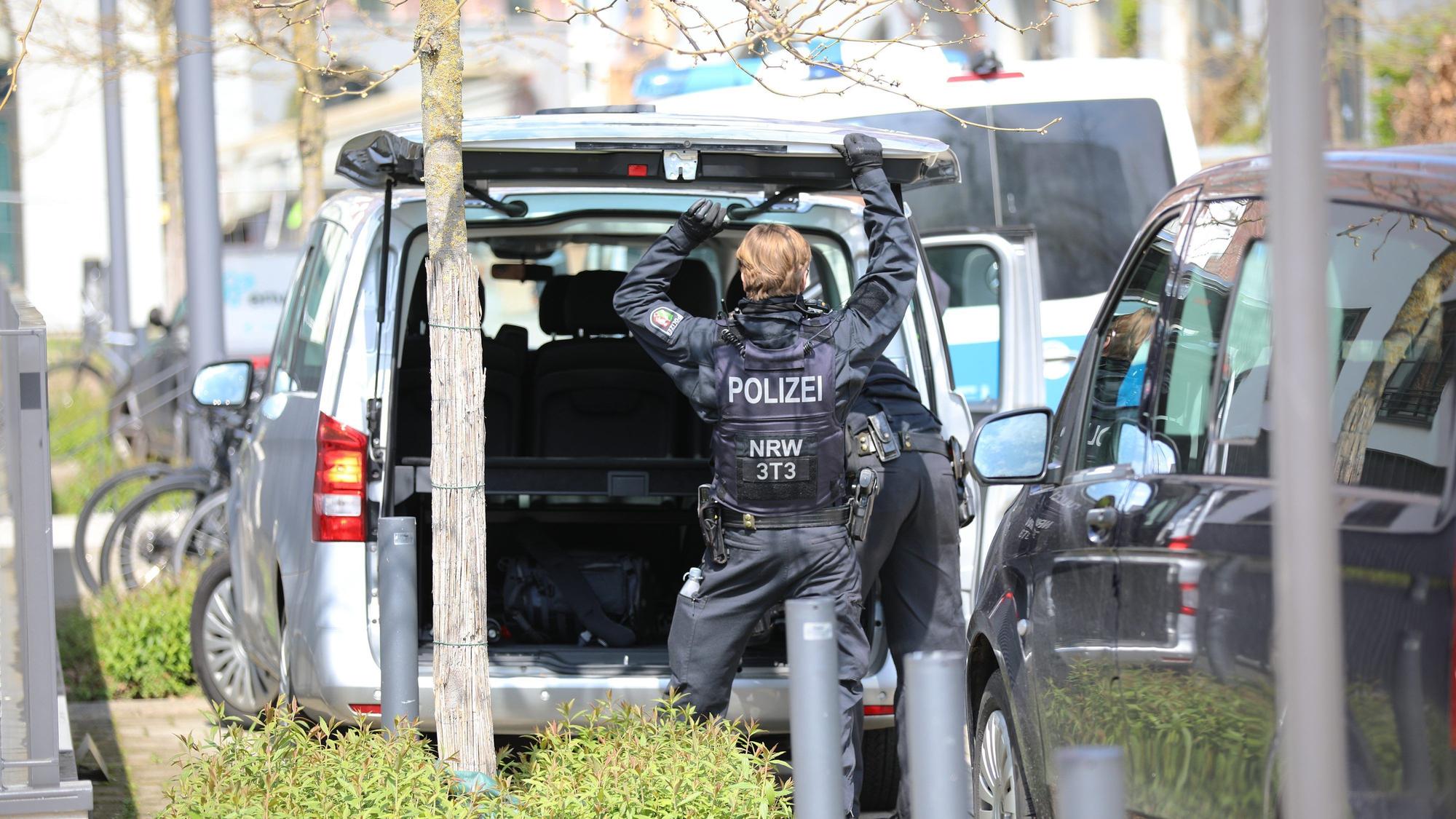 Ein Polizist steht an einem Auto.