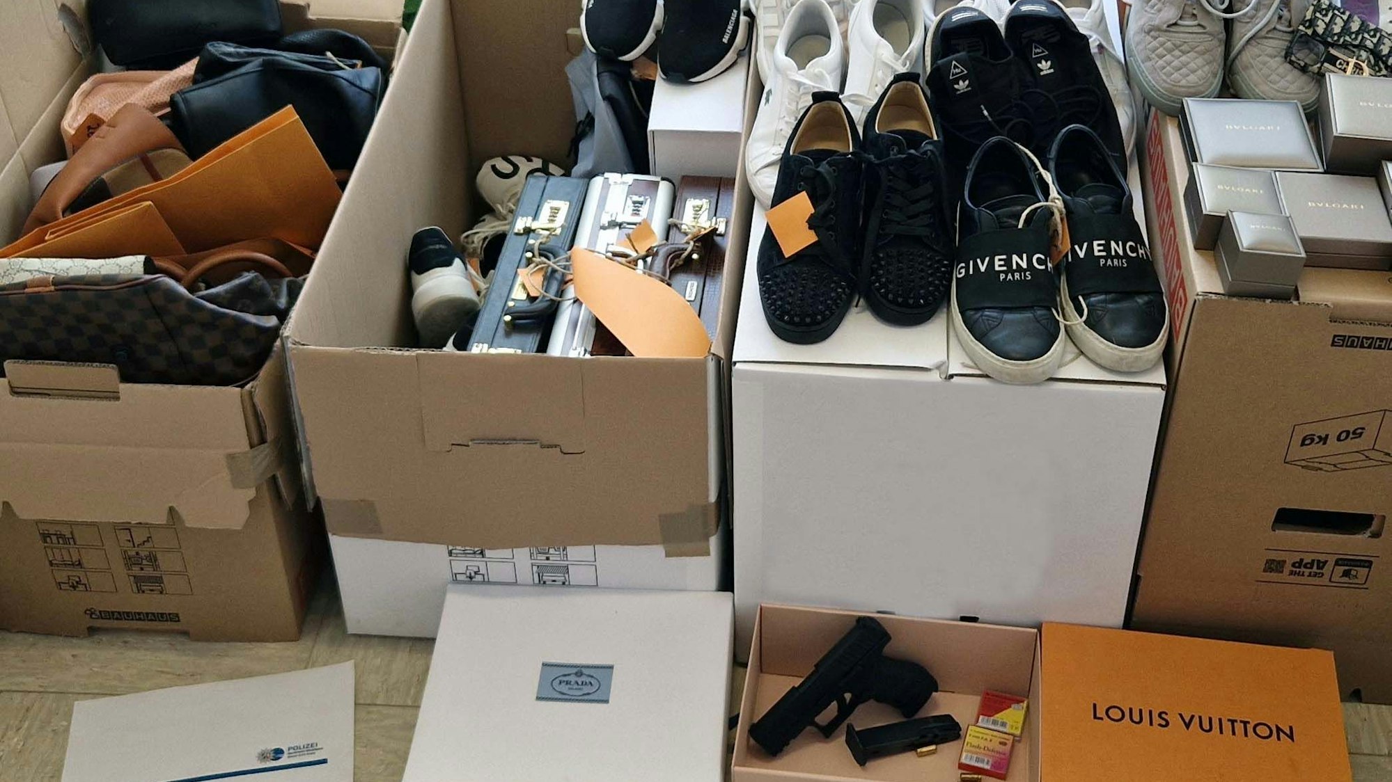 In und auf Karton befinden sich Designer-Taschen und -Schuhe.