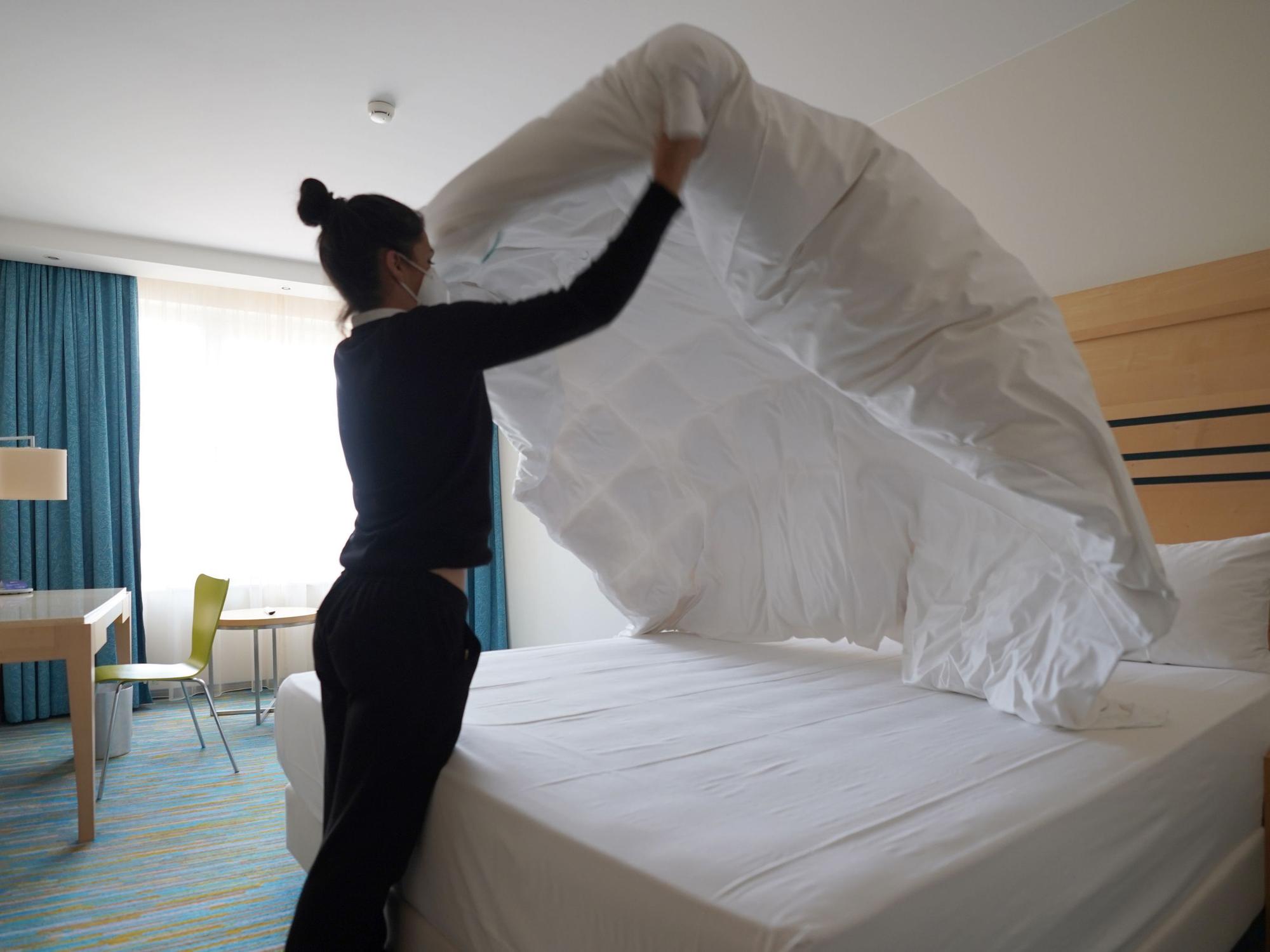 Eine Mitarbeiterin reinigt ein Hotelzimmer, hier im Juni 2021 in Hamburg.