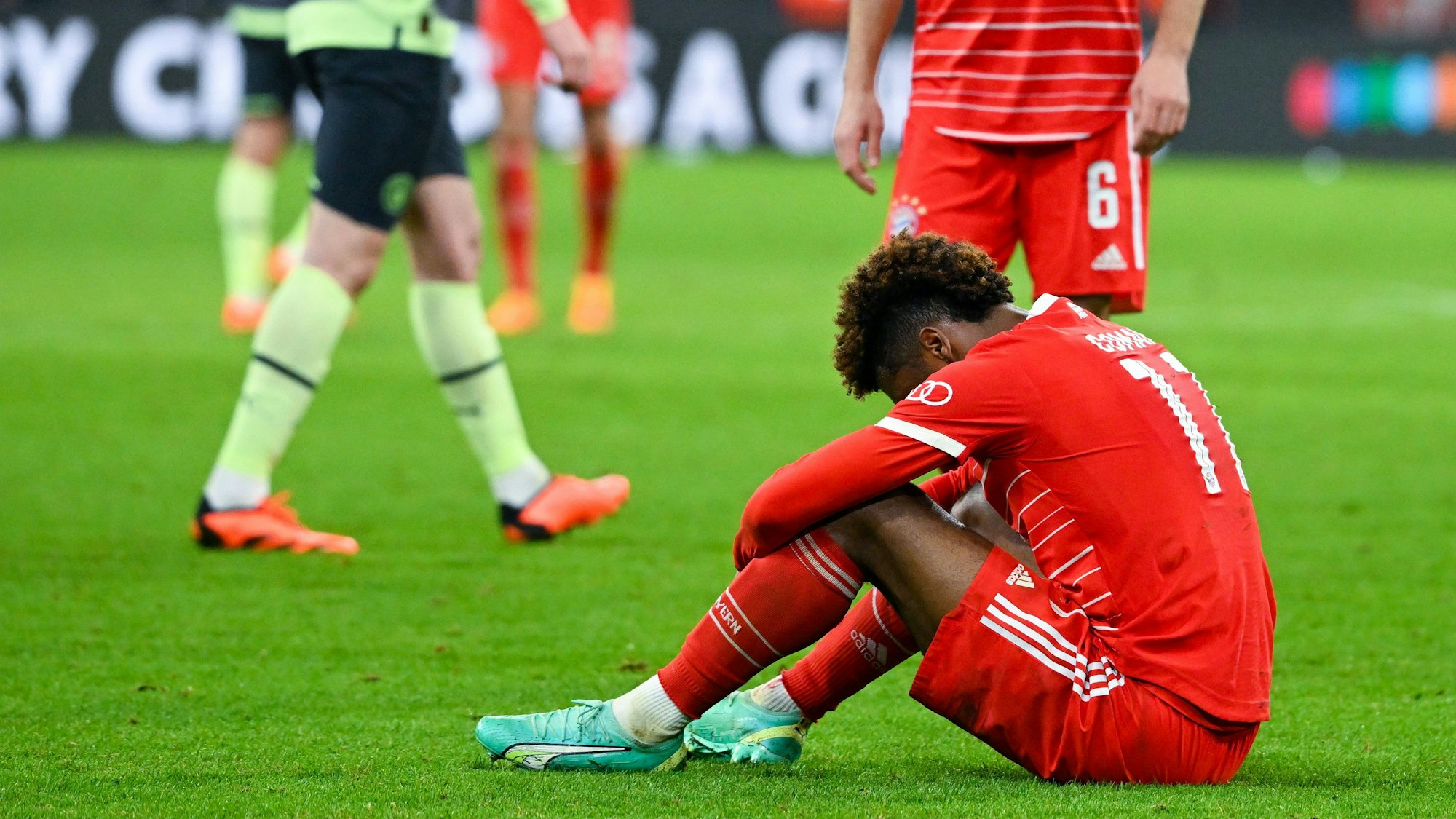 Kingsley Coman sitzt enttäuscht auf dem Spielfeld nach der Niederlage gegen Manchester City.