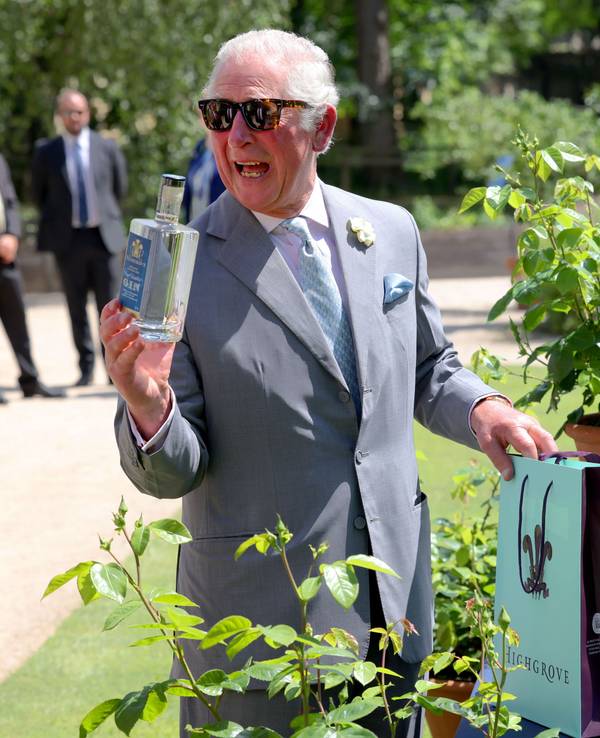 König Charles III. am 8. Juni 2021 mit einer Flasche Gin in der Hand in einem Garten in Oxford.