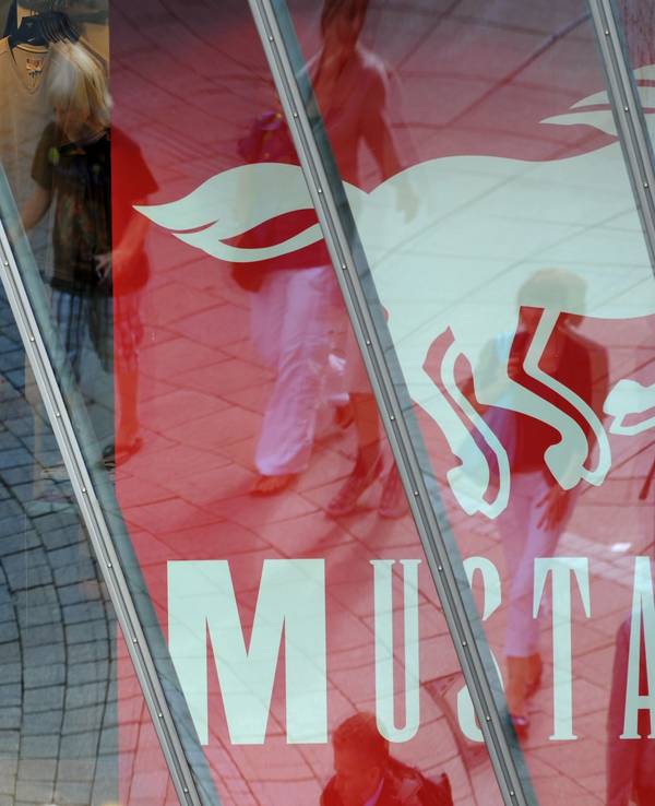 ARCHIV - Passanten auf der Königstraße in der Innenstadt von Stuttgart (Baden-Würtemberg) spiegeln sich in einer Schaufensterscheibe eines Mustang-Stores. Der Jeanshersteller Mustang will seinen Wachstumskurs im Jahr 2014 mit einem Ausbau des Großhandels fortsetzen. Geschäftsführer Axt rechnet 2014 erneut mit einem Umsatzplus von rund 20 Prozent, wie das Unternehmen mit Sitz in Künzelsau am 08.01.2014 mitteilte. Foto: Marijan Murat/dpa (zu lsw: «Jeanshersteller Mustang will mit Großhandelsgeschäft wachsen» vom 08.01.2014) +++ dpa-Bildfunk +++
