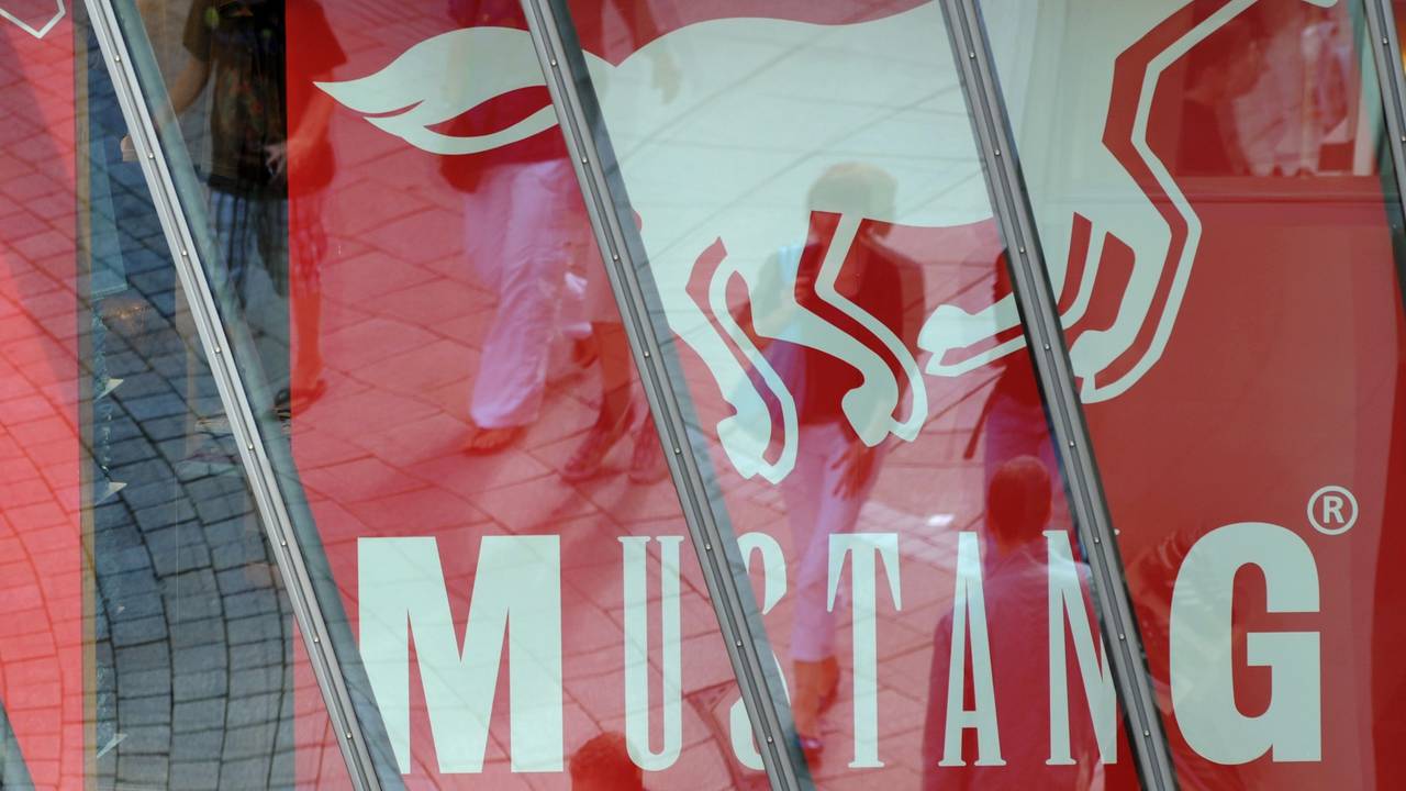 ARCHIV - Passanten auf der Königstraße in der Innenstadt von Stuttgart (Baden-Würtemberg) spiegeln sich in einer Schaufensterscheibe eines Mustang-Stores. Der Jeanshersteller Mustang will seinen Wachstumskurs im Jahr 2014 mit einem Ausbau des Großhandels fortsetzen. Geschäftsführer Axt rechnet 2014 erneut mit einem Umsatzplus von rund 20 Prozent, wie das Unternehmen mit Sitz in Künzelsau am 08.01.2014 mitteilte. Foto: Marijan Murat/dpa (zu lsw: «Jeanshersteller Mustang will mit Großhandelsgeschäft wachsen» vom 08.01.2014) +++ dpa-Bildfunk +++