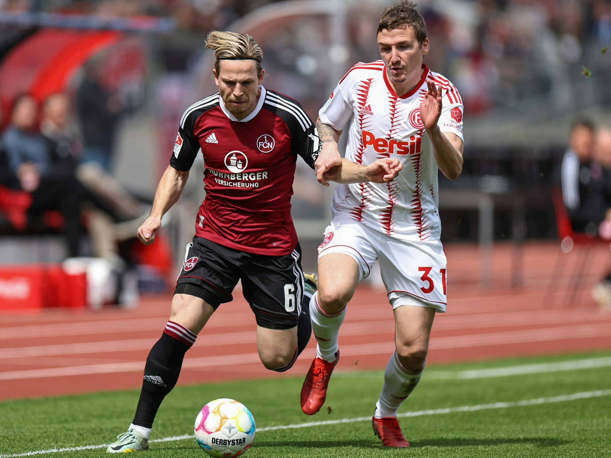 Der Nürnberger Lino Tempelmann kämpft mit Marcel Sobottka von Fortuna Düsseldorf um den Ball.