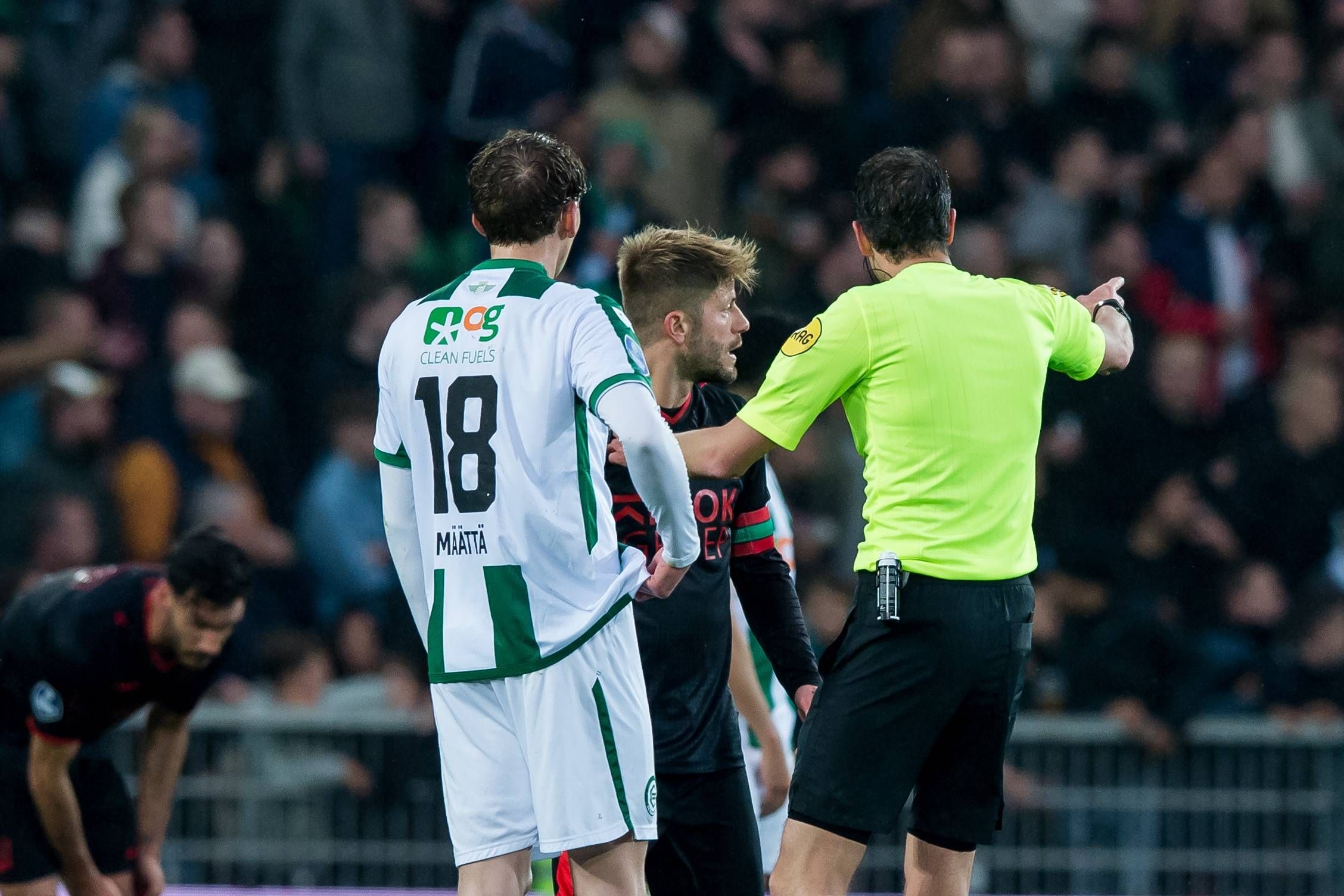 Isak Maatta (l., FC Groningen), Lasse Schone (Mitte, NEC Nijmegen) und Schiedsrichter Richard Martens während der Eredivisie-Partie zwischen den beiden Teams am 22. April 2023.