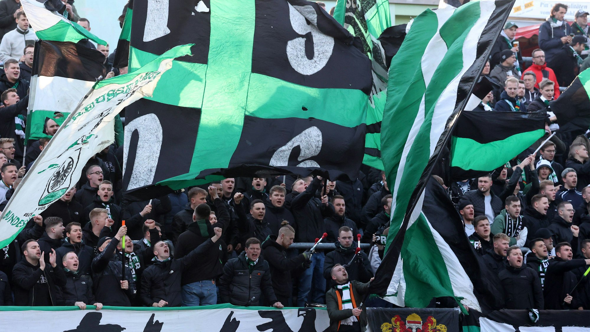 Fans des SC Preußen Münster schwenken Fahnen.