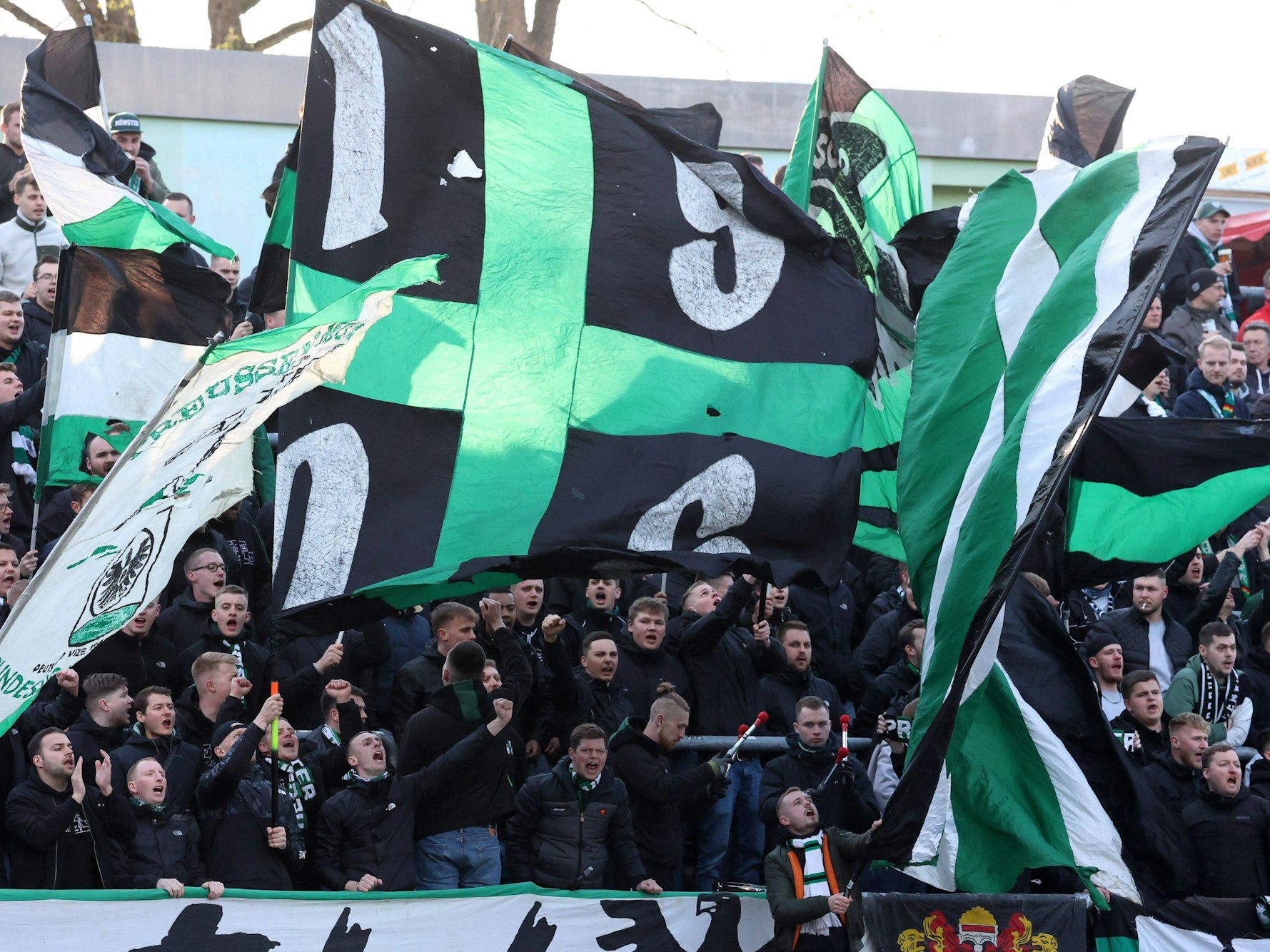 Fans des SC Preußen Münster schwenken ihre Fahnen.