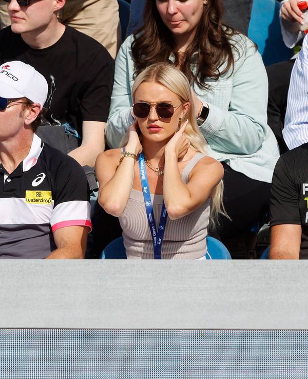 Morgan Riddle (M.) sitzt mit Sonnenbrille auf der Tribüne bei der Partie zwischen Taylor Fritz und Botic van de Zandschulp.