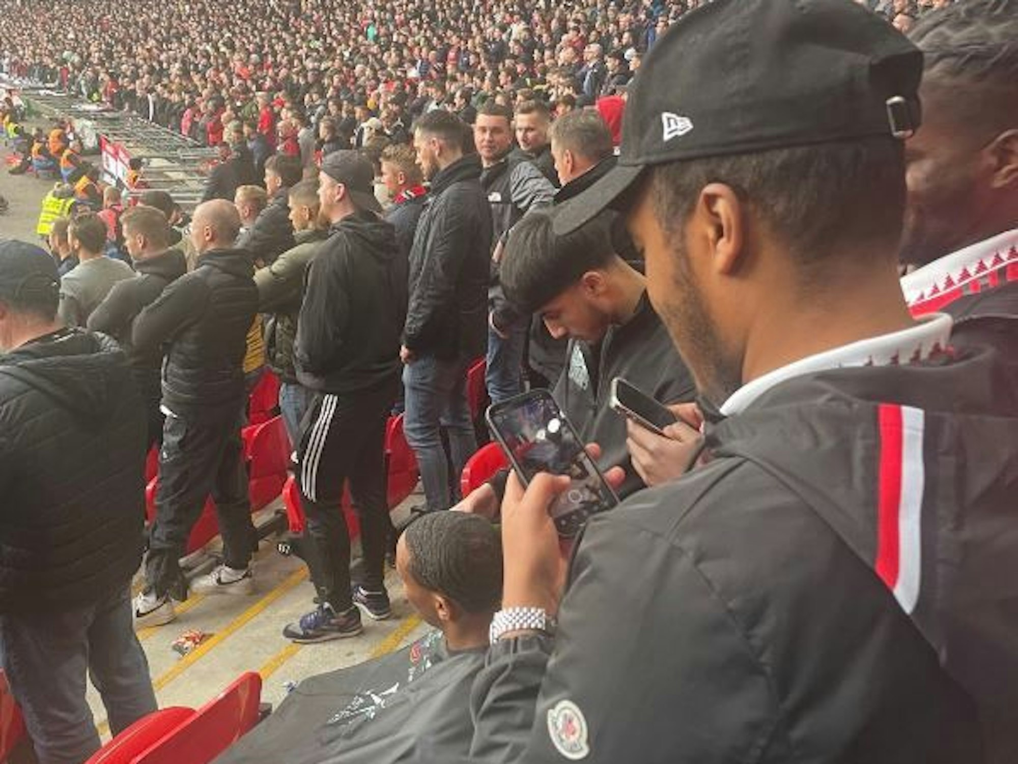 Ein Fan bekommt im Stadion die Haare geschnitten.