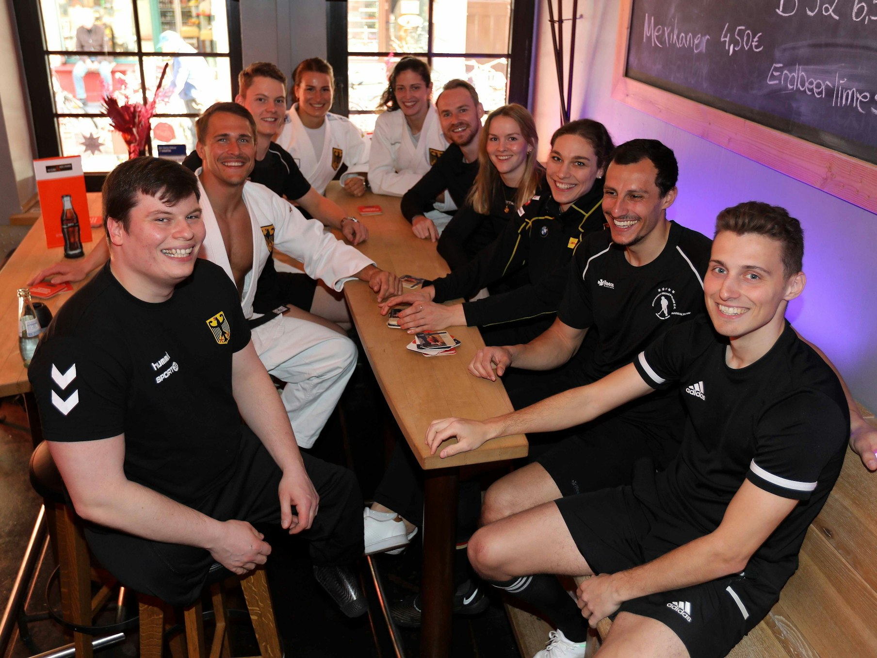 Der Verbund Kölner Athleten sitzt am Tisch.