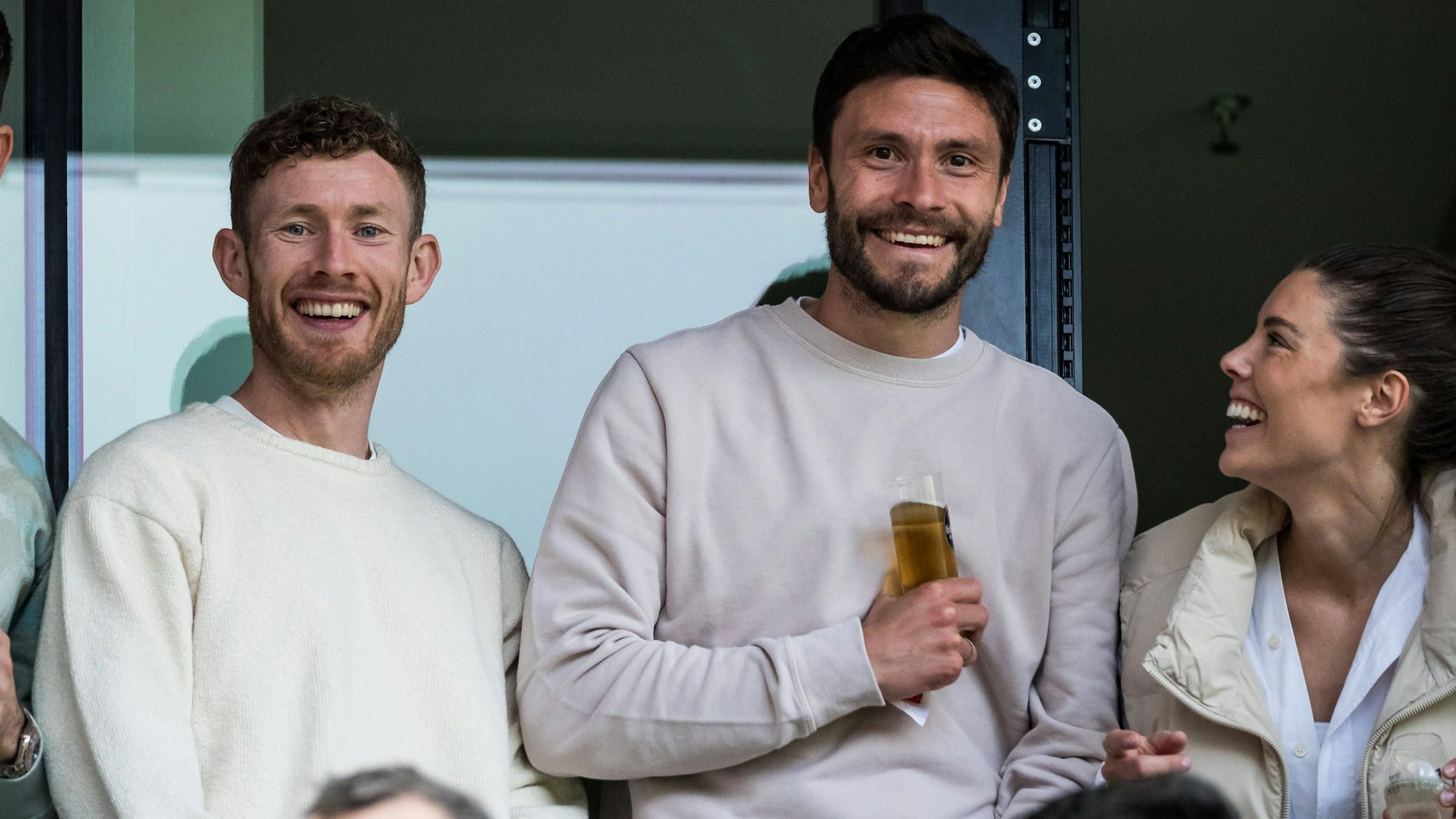 Jonas Hector lacht beim Spiel der FC-Frauen im Rhein-Energie-Stadion mit seiner Frau Anika und Florian Kainz.