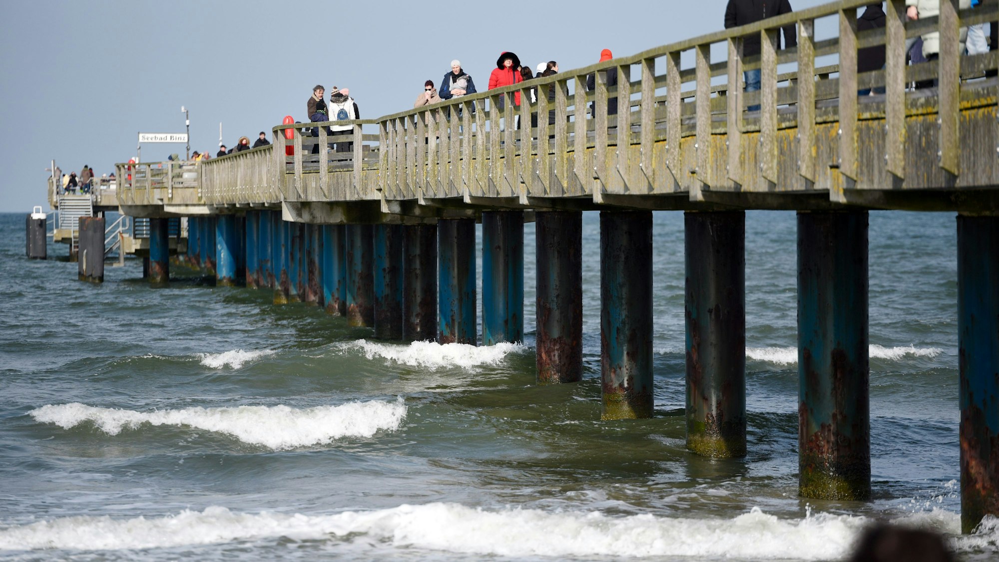 Spaziergänger laufen auf der Seebrücke vom Ostseebad Binz auf der Insel Rügen.