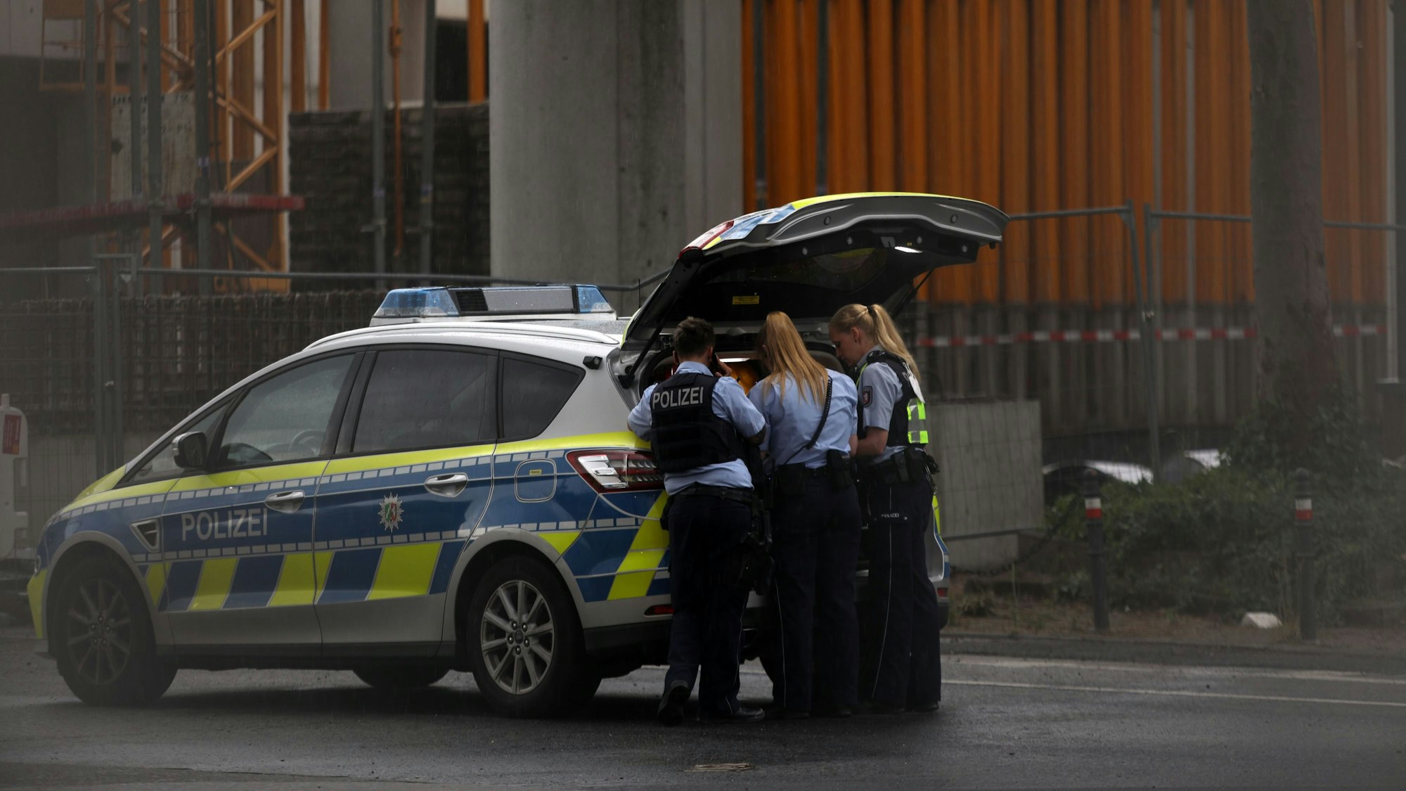 Polizeikräfte stehen an einem Polizeifahrzeug mit geöffnetem Kofferraum. Nach einer Polizeikontrolle am Samstagnachmittag (22. April 2023) flüchtete ein Mercedes-Fahrer.