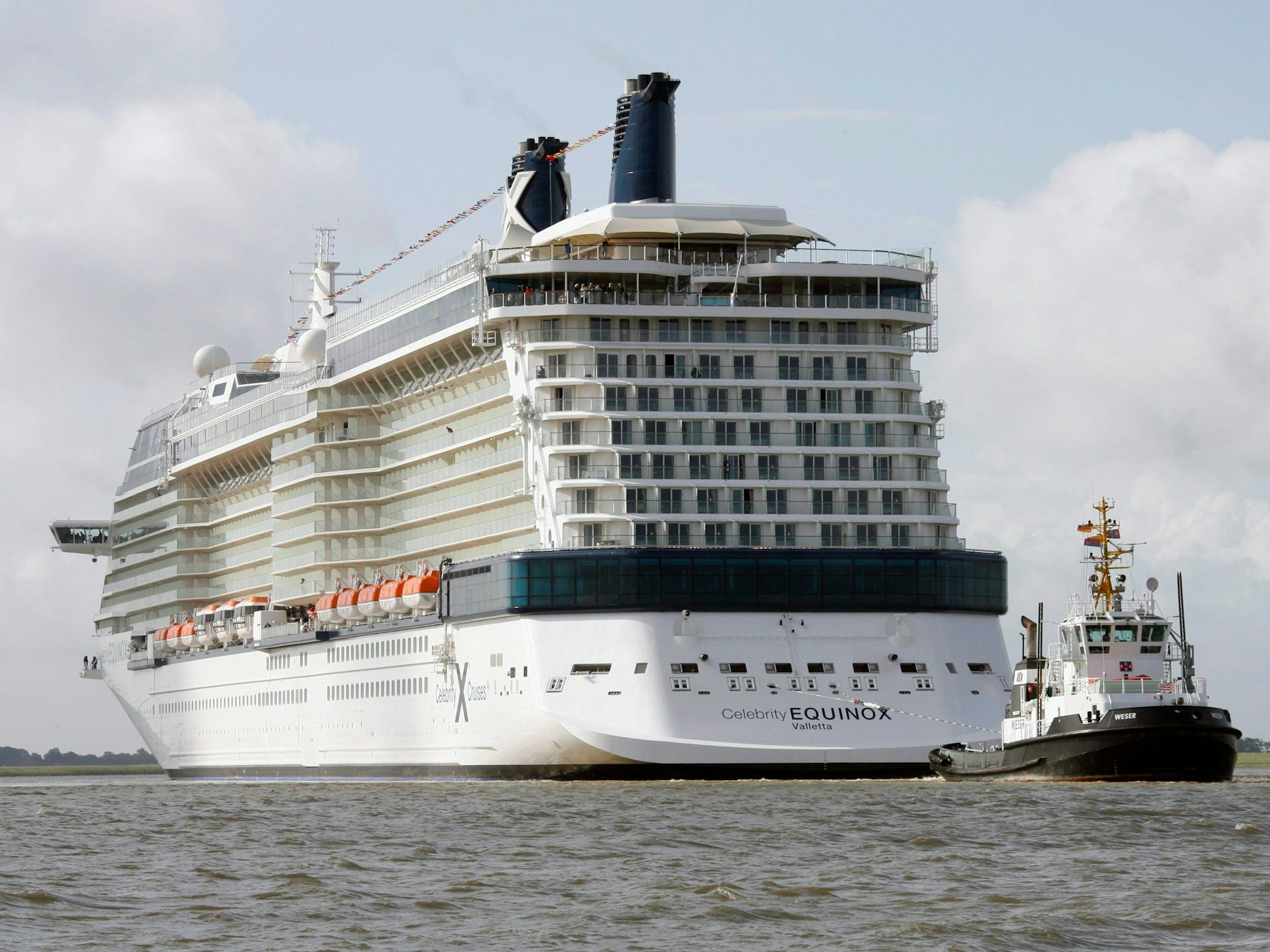 Hier zu sehen, das Kreuzfahrtschiff „Celebrity Equinox“ auf der Ems. Ein Schlepper fährt voraus.